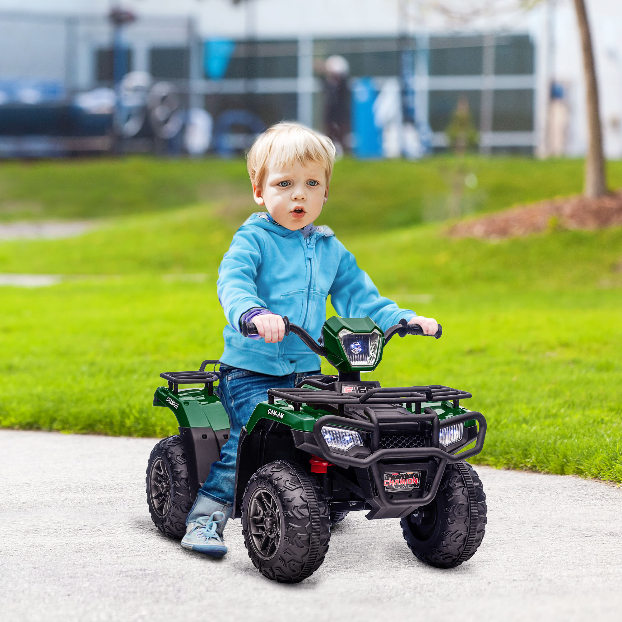 Un bambino piccolo su un ATV verde. L'ATV ha ruote nere e il bambino indossa una felpa con cappuccio blu.