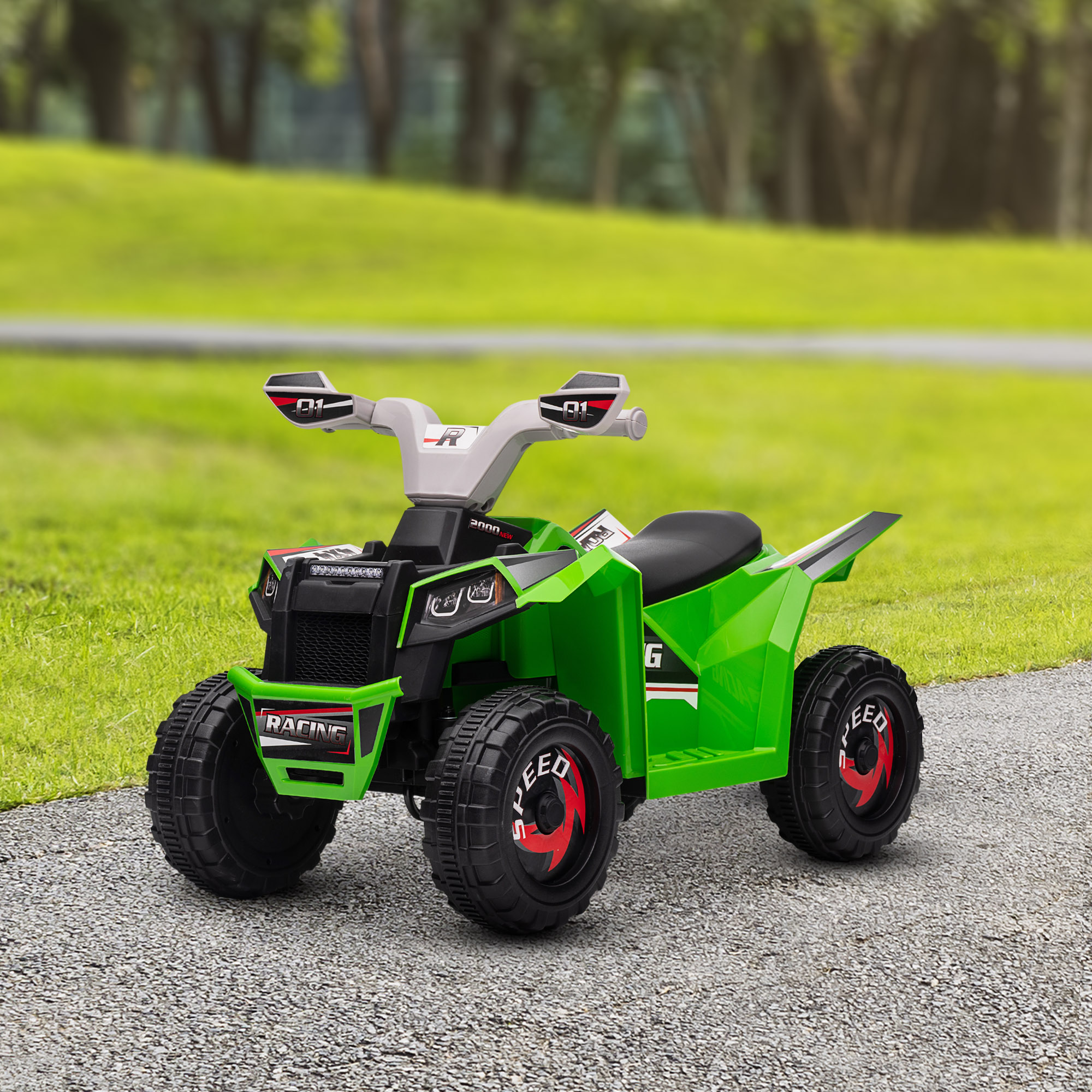 Un ATV verde su una superficie di ghiaia. Ha pneumatici neri con accenti rossi, lo sfondo è verde sfocato.