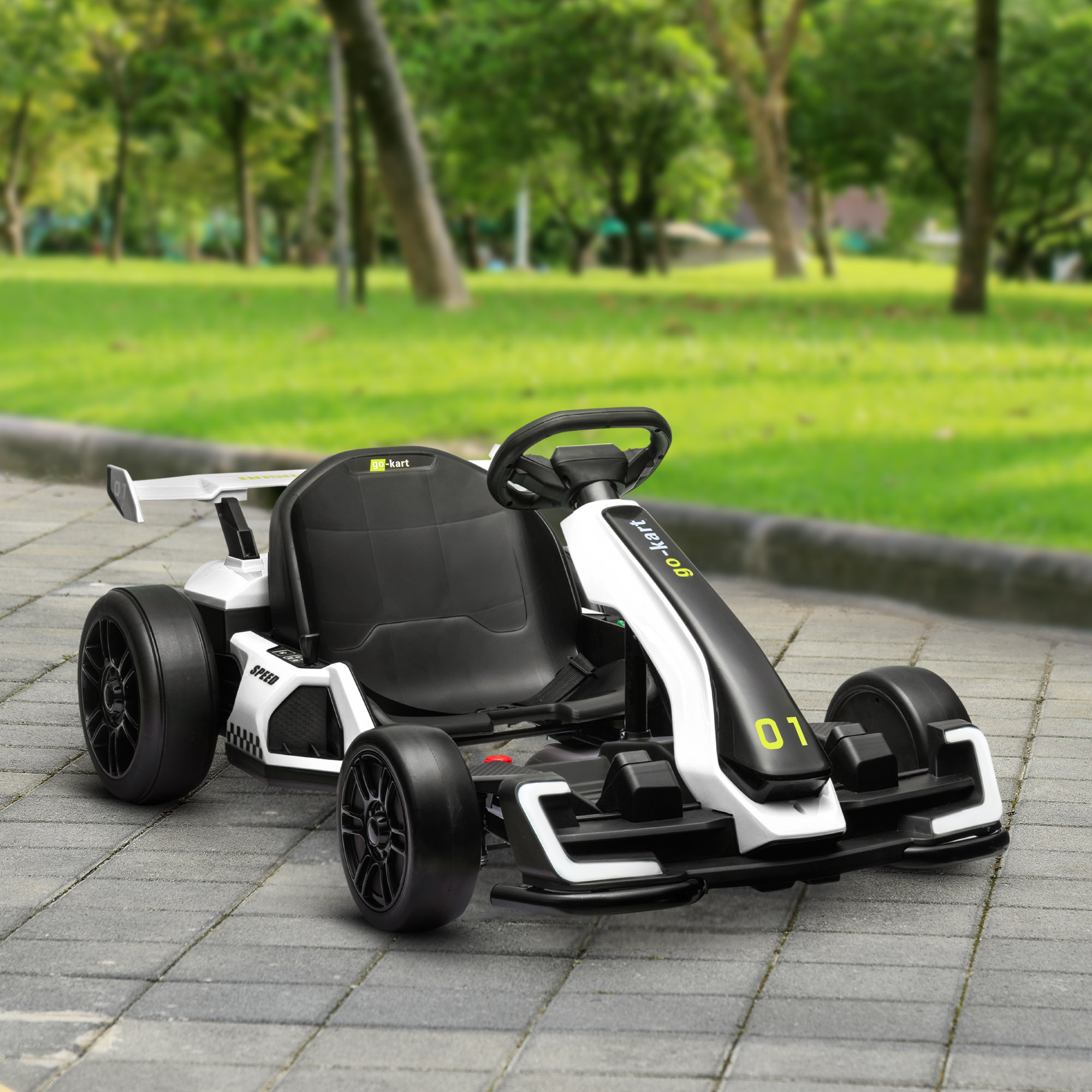 Go-kart bianco con sedile nero e frontale verde, su un sentiero pavimentato, con alberi sullo sfondo.