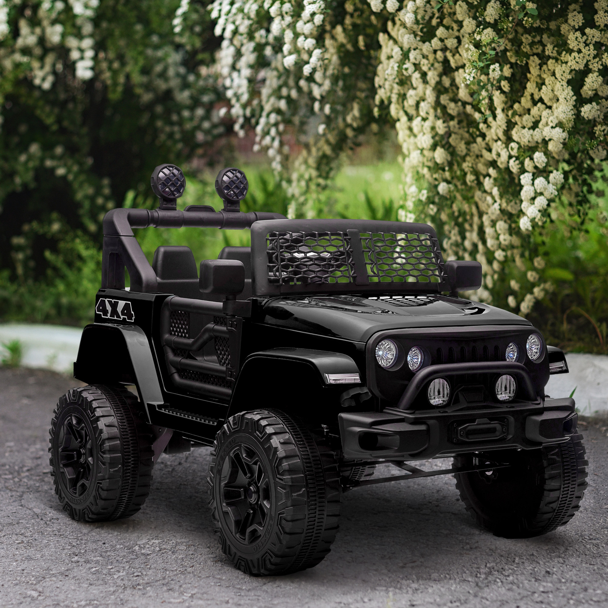 Una jeep giocattolo nera con logo 4x4. Ha pneumatici grandi e luci, parcheggiata su una superficie grigia.