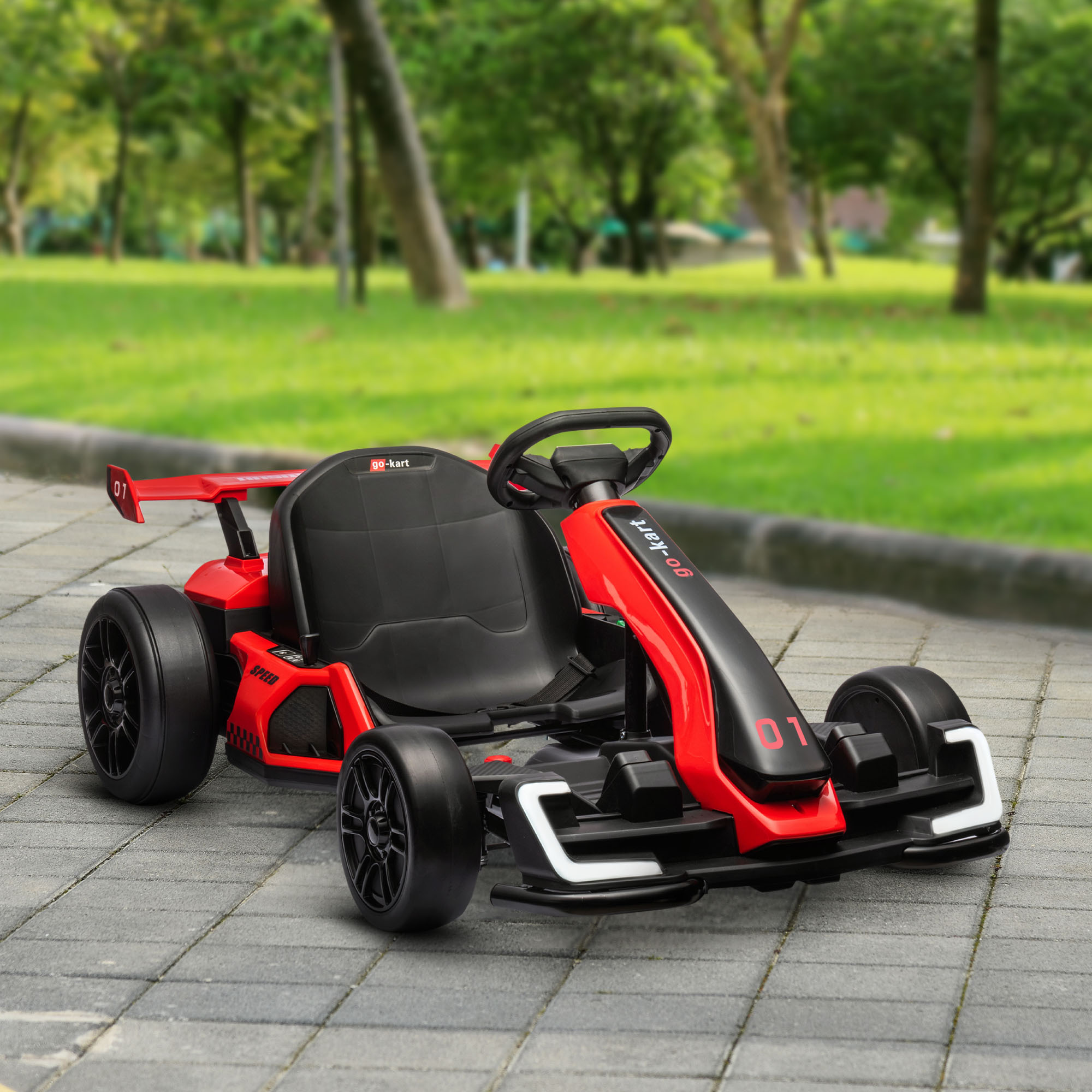Go-kart rosso con sedile nero e frontale rosso, su un sentiero pavimentato, con alberi sullo sfondo.