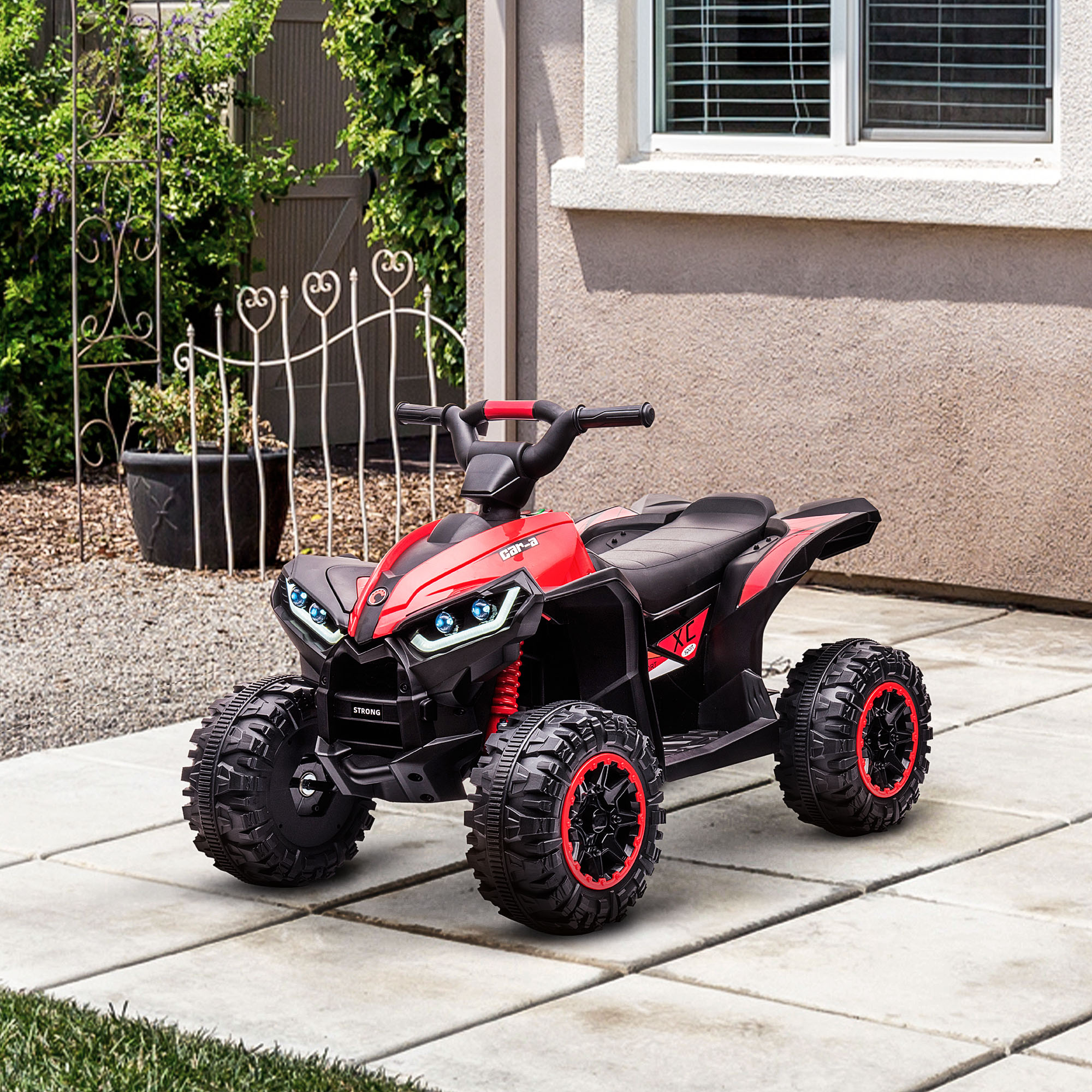 ATV giocattolo rosso su un patio. Pneumatici neri e luci LED, con una casa sullo sfondo.