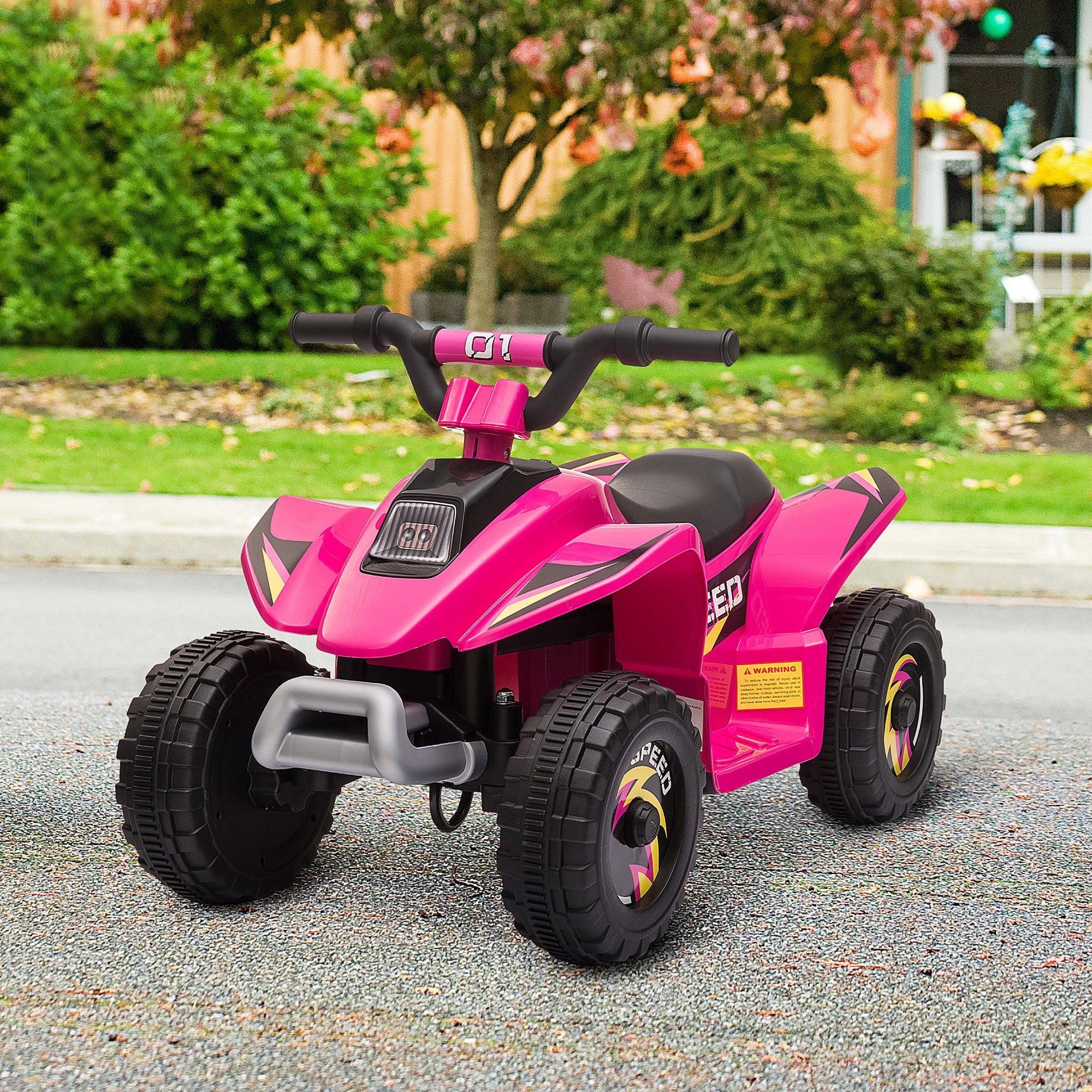 Un quad giocattolo rosa è su una superficie pavimentata. Ha ruote nere e un piccolo manubrio.