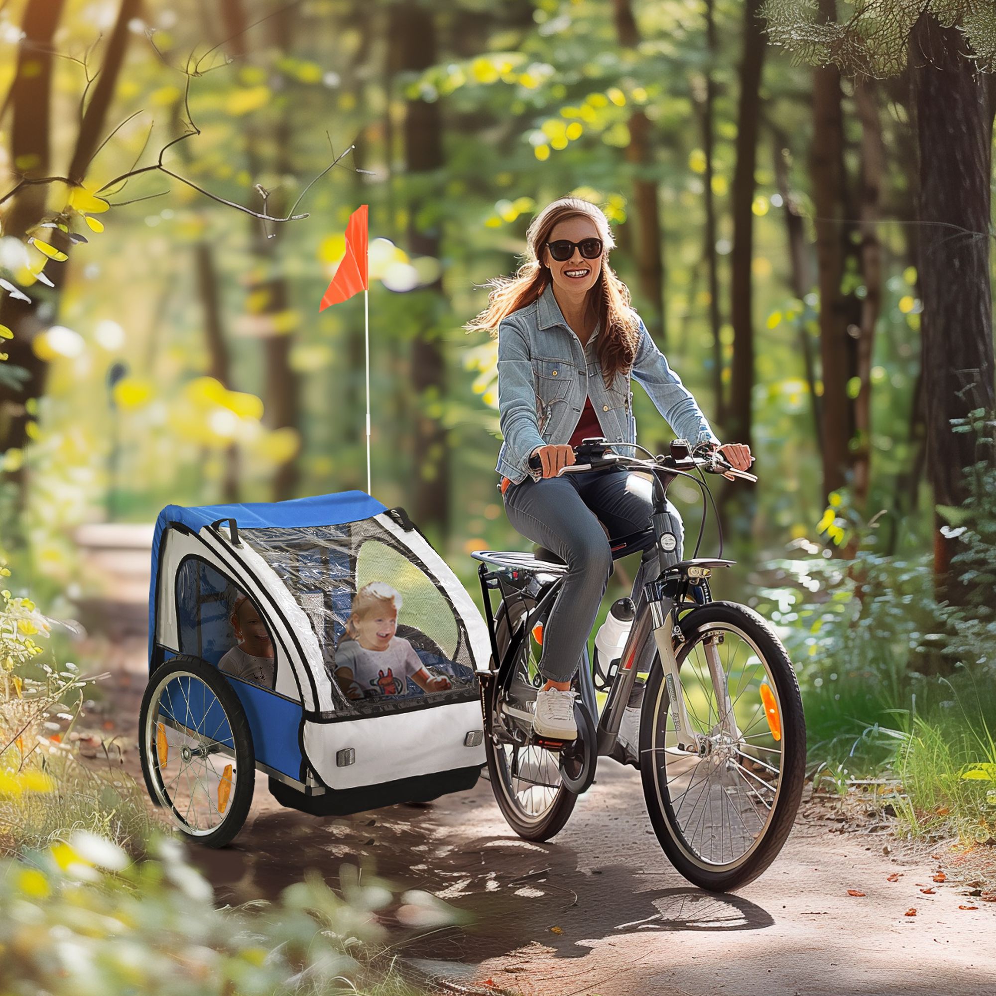 Donna in bicicletta che tira un rimorchio per bambini su un sentiero.