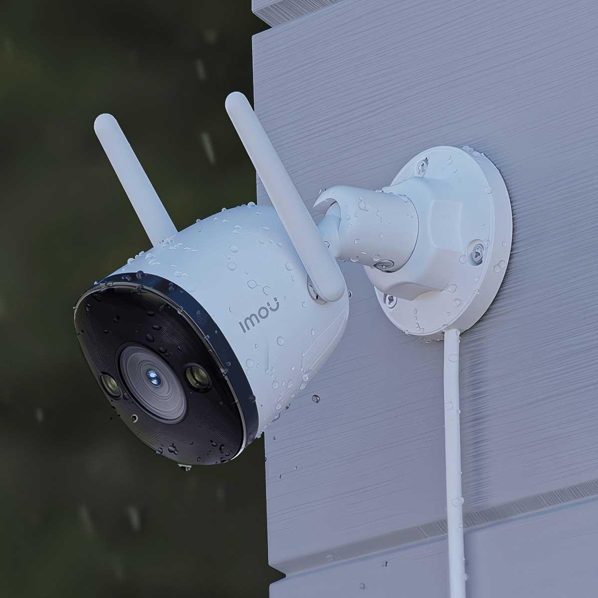 Biała kamera monitoringu na szarej ścianie, krople wody.