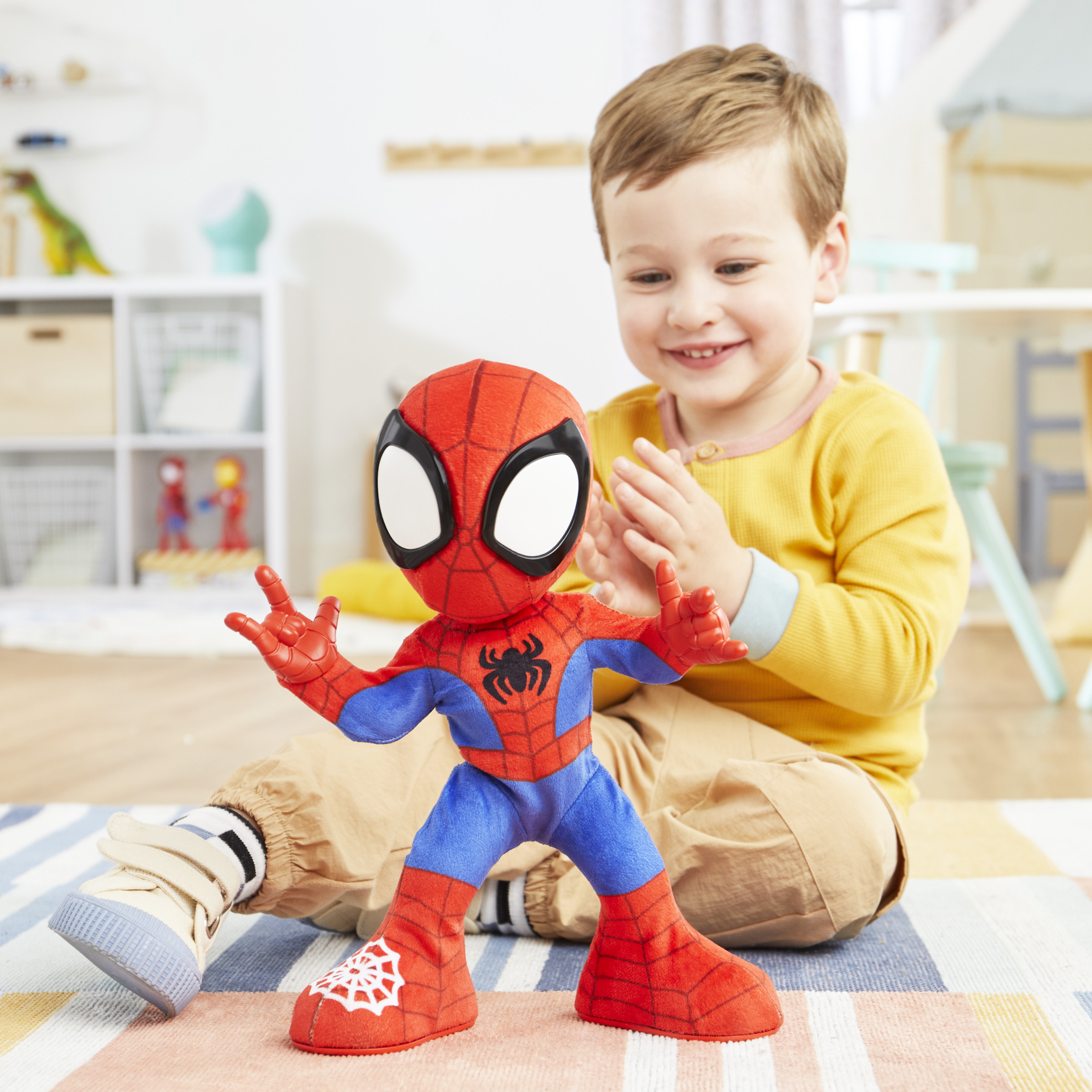 Un niño con un muñeco de Spider-Man. El muñeco tiene ojos grandes y está jugando.