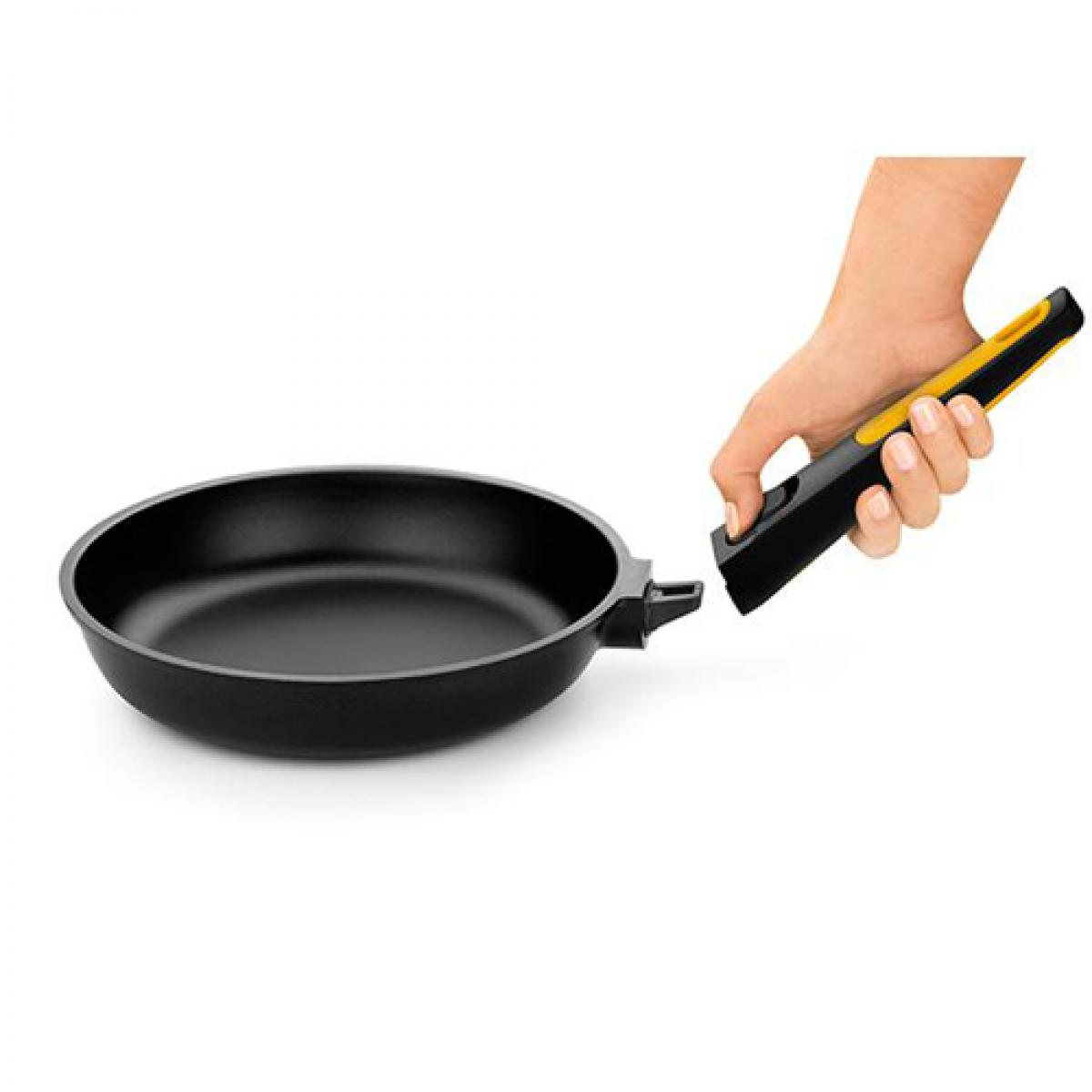 Sartén negra con una herramienta con mango amarillo que la señala.