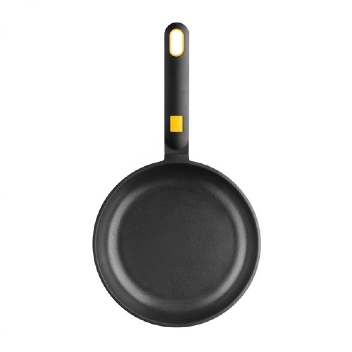 Sartén negra con mango largo, acento amarillo en la base del mango.