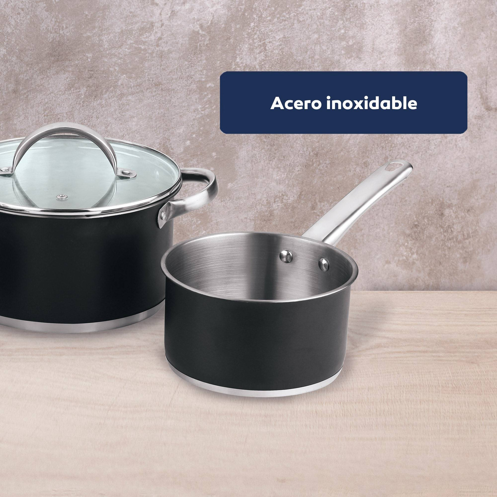 Dos ollas, una con tapa, y una pequeña cacerola. Todos son de acero inoxidable con un fondo de madera.