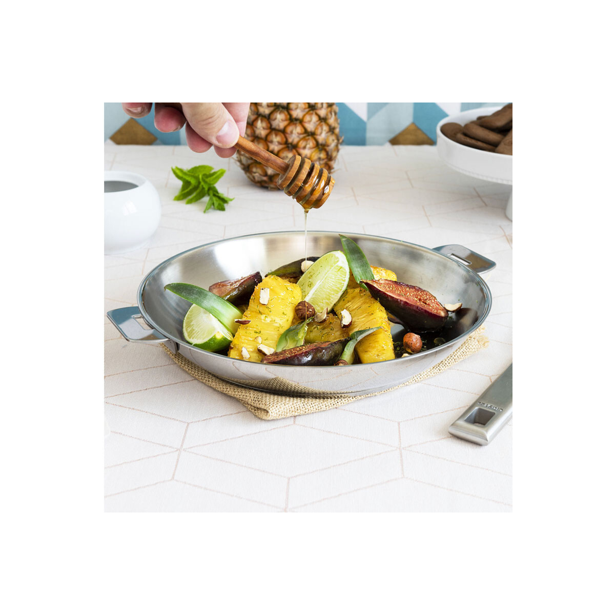 Danie z jedzeniem: Ananas, figi i plasterki limonki w srebrnej misce. Polane miodem.