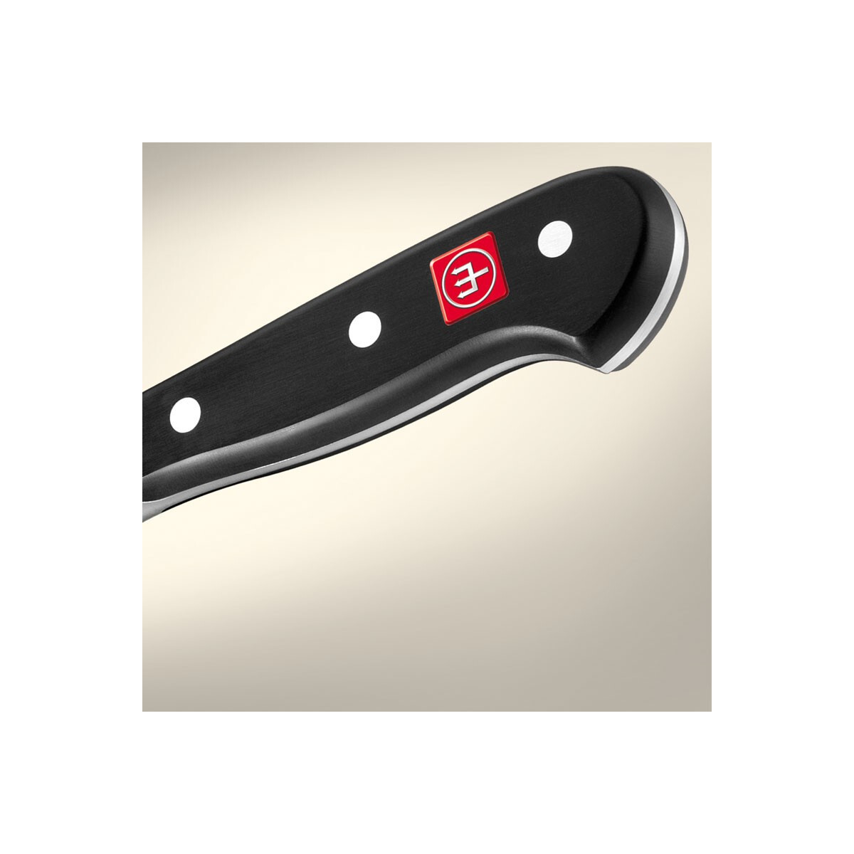 Primer plano de un mango de cuchillo. Mango blanco y negro. Logotipo rojo. El mango está en ángulo.