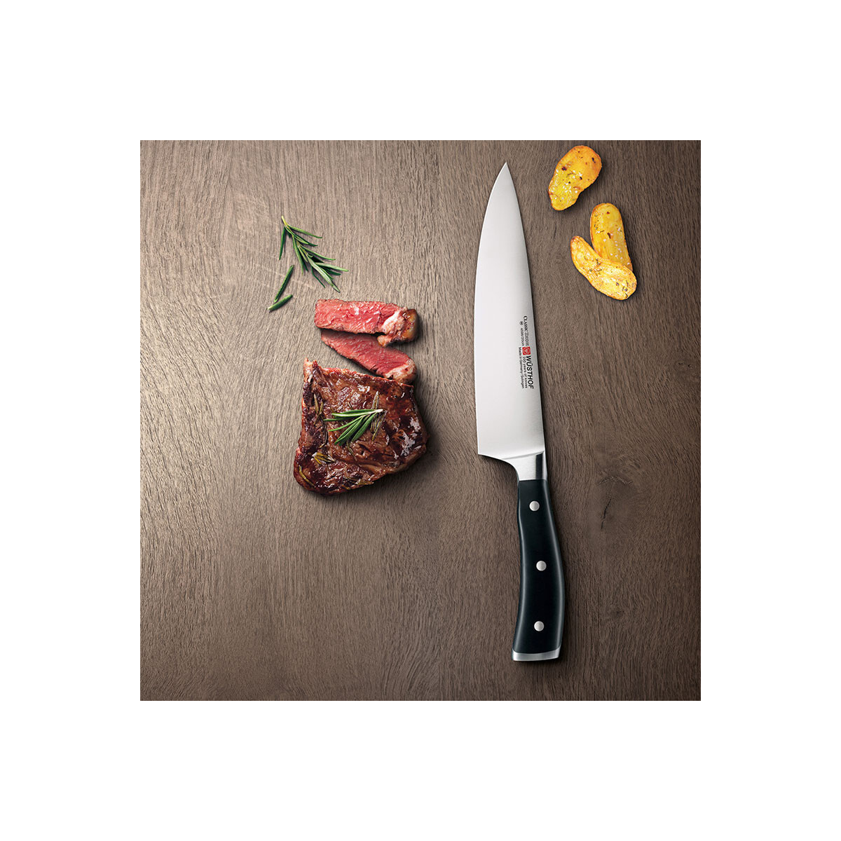 Ein Messer mit schwarzem Griff neben einem aufgeschnittenen Steak und kleinen Brotscheiben auf Holz.