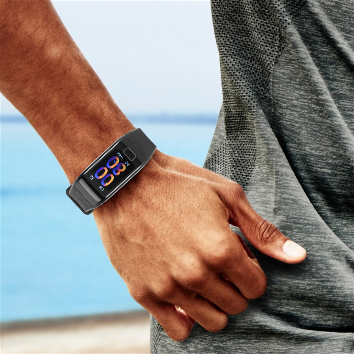 Arm eines Mannes mit schwarzem Fitnesstracker am Handgelenk, blauer Hintergrund.