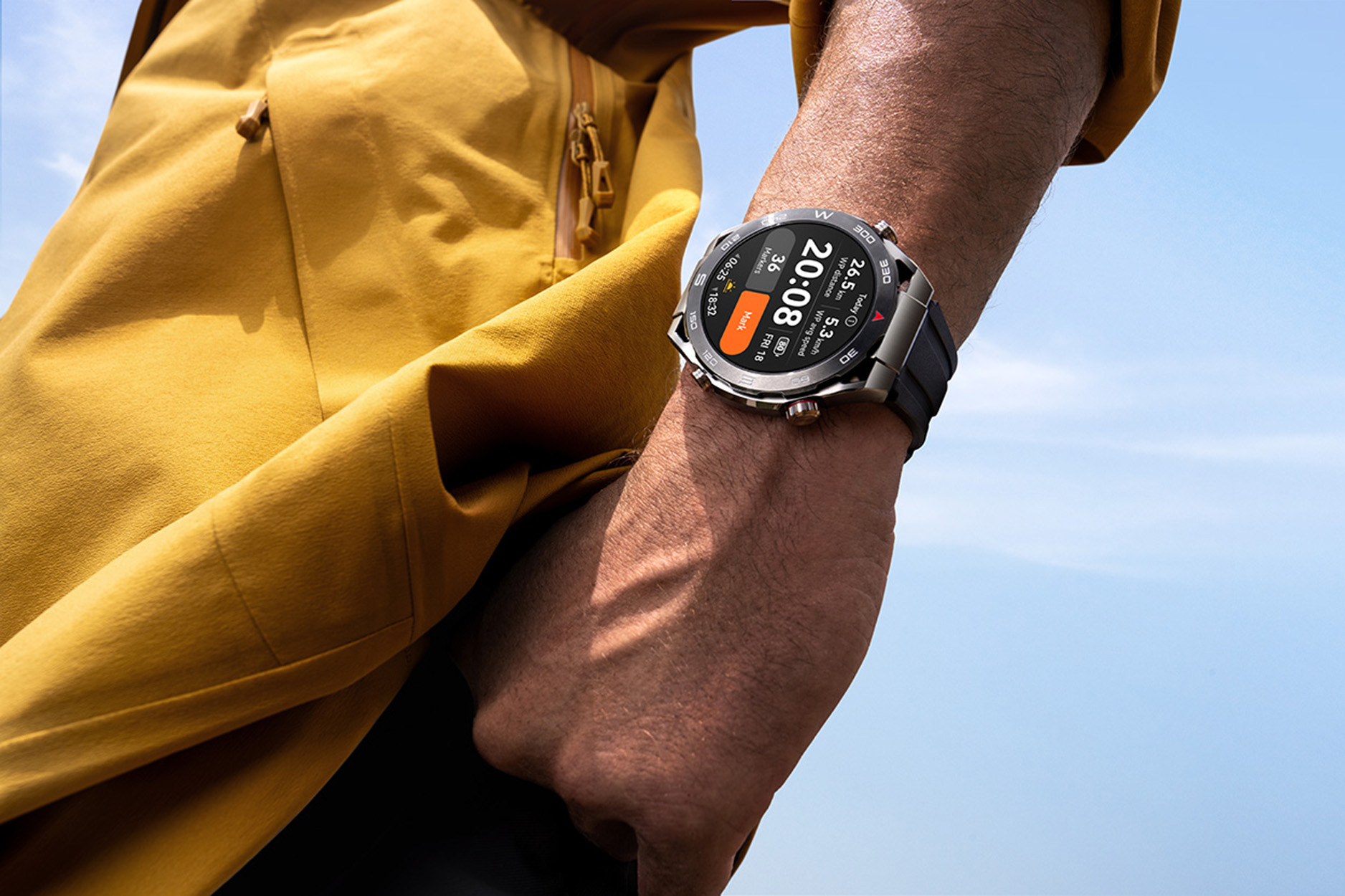 Polso maschile con uno smartwatch, sullo sfondo di un cielo soleggiato. Lo smartwatch mostra ora, data e statistiche.