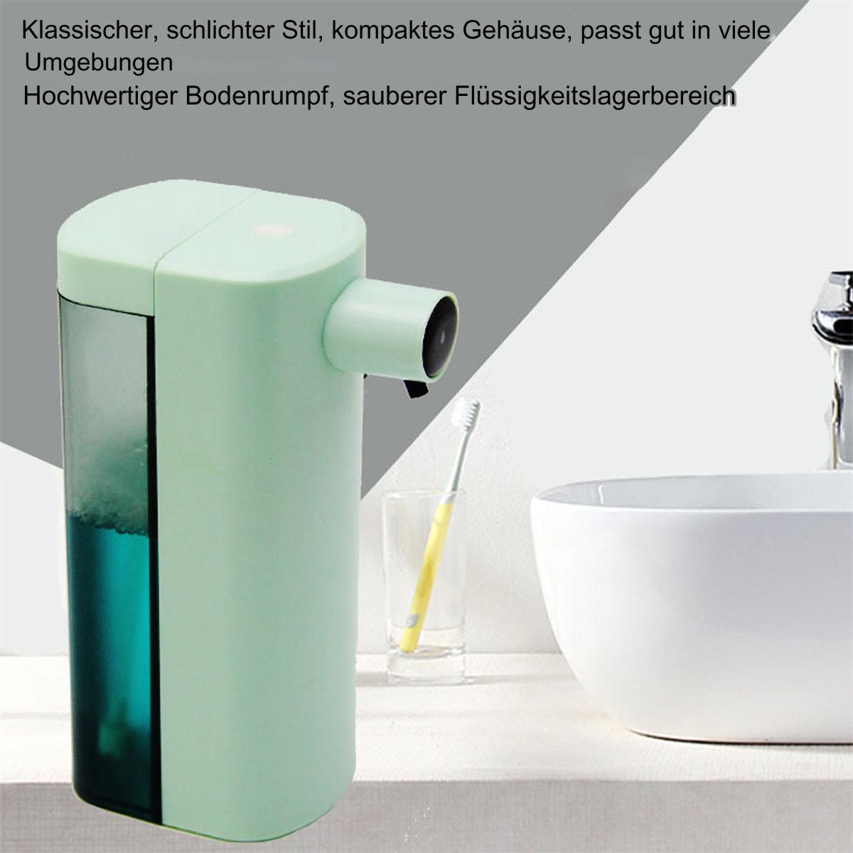 Ein mintgrüner automatischer Seifenspender neben einem Waschbecken mit einer Zahnbürste.