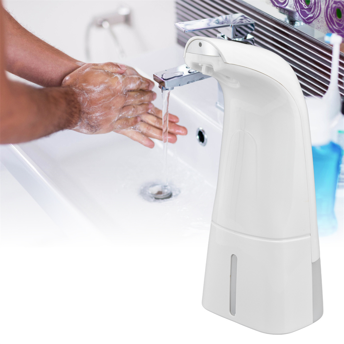 Ein weißer Seifenspender mit Händen, die unter dem Wasserhahn gewaschen werden. Der Spender steht auf einem weißen Waschbecken.