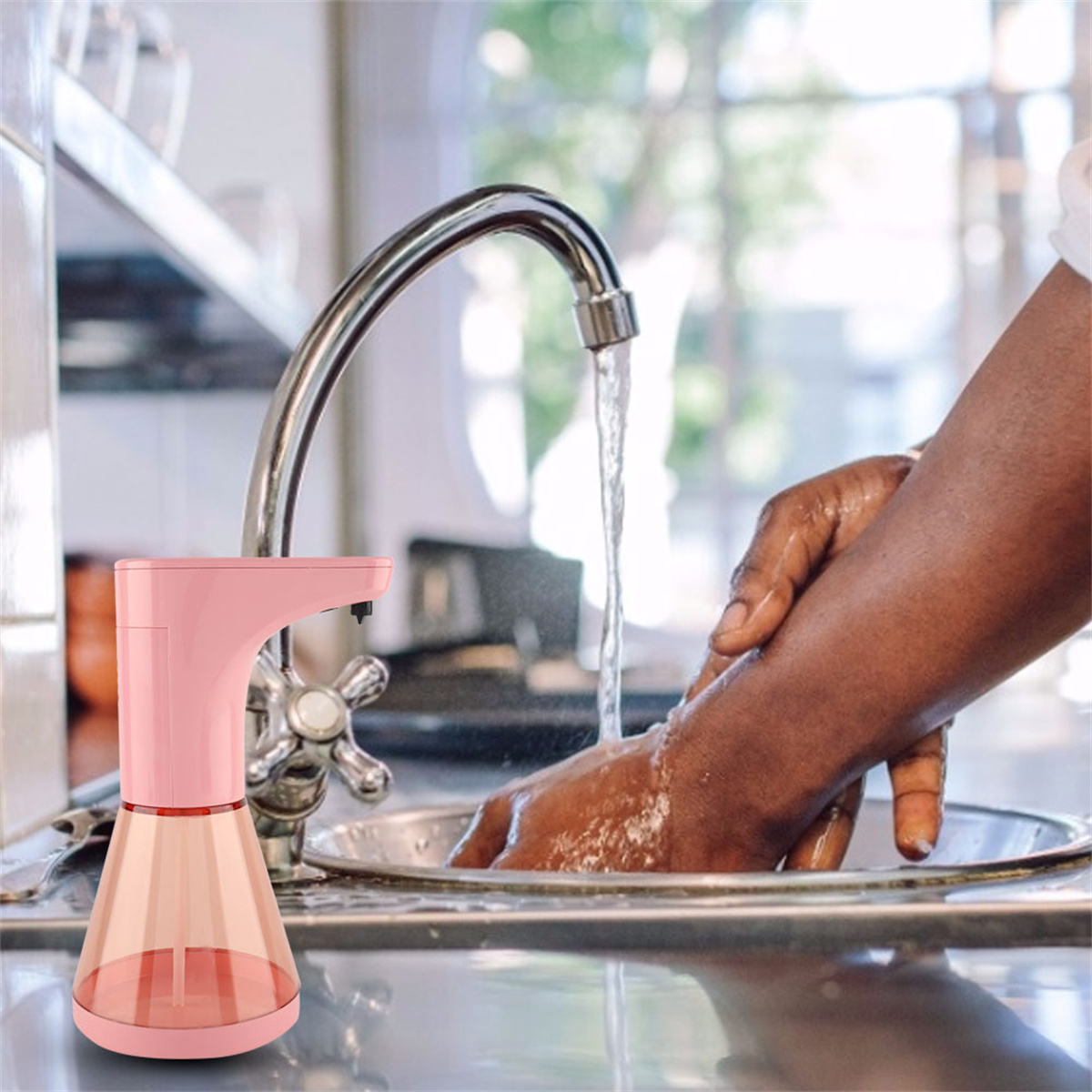 Ein rosa automatischer Seifenspender gibt Wasser in eine Hand ab, Spüle im Hintergrund.