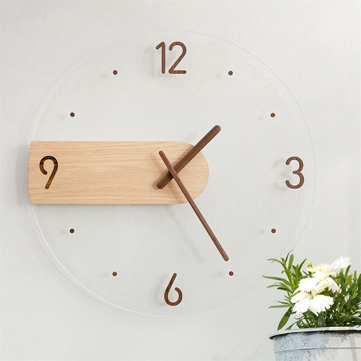 Transparente Uhr mit Holzsockel bei 9. Zeiger bei 10:15. Ziffern sind braun.