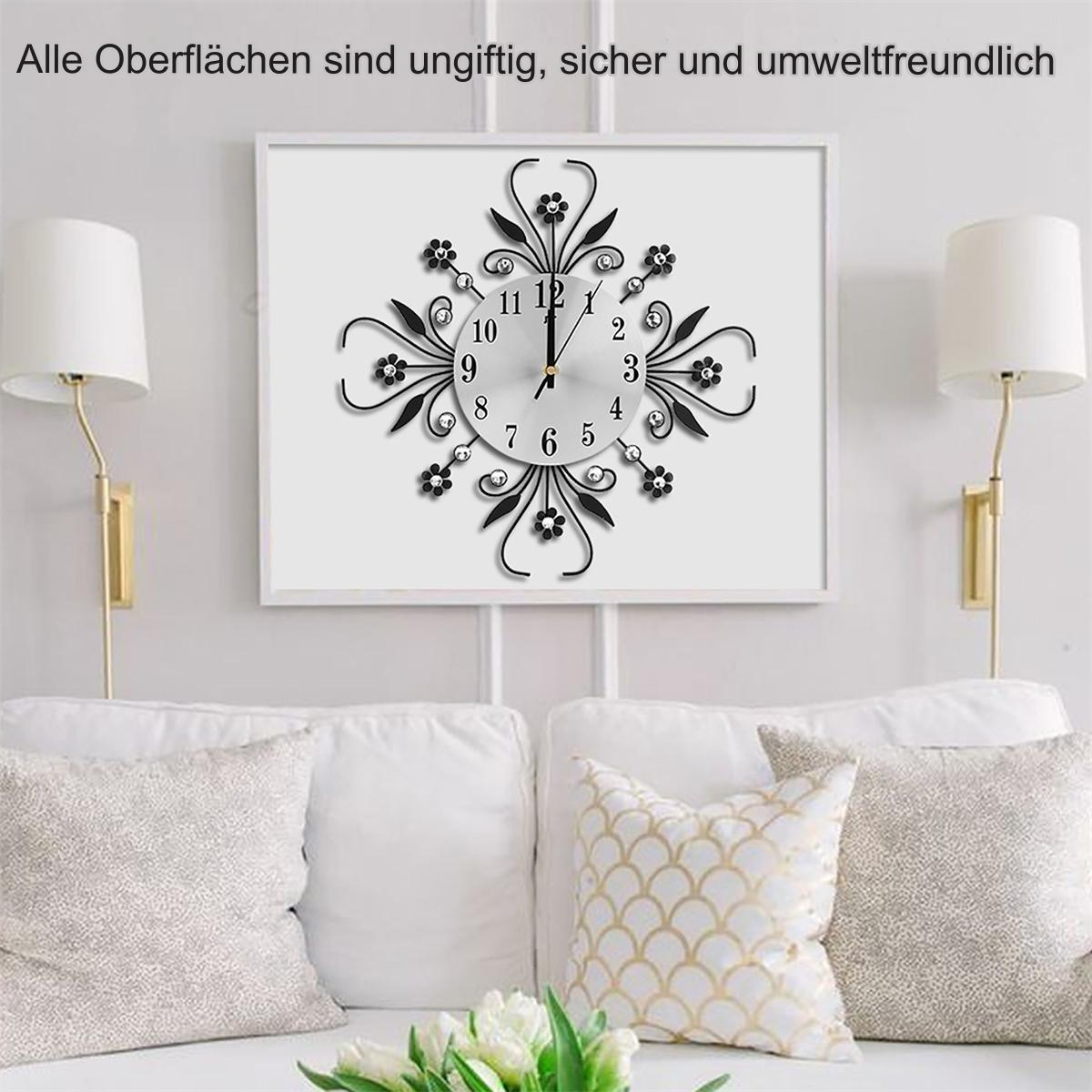 Uhr an einer weißen Wand, gerahmt. Zwei Lampen auf beiden Seiten, weißes Sofa und Kissen unten.
