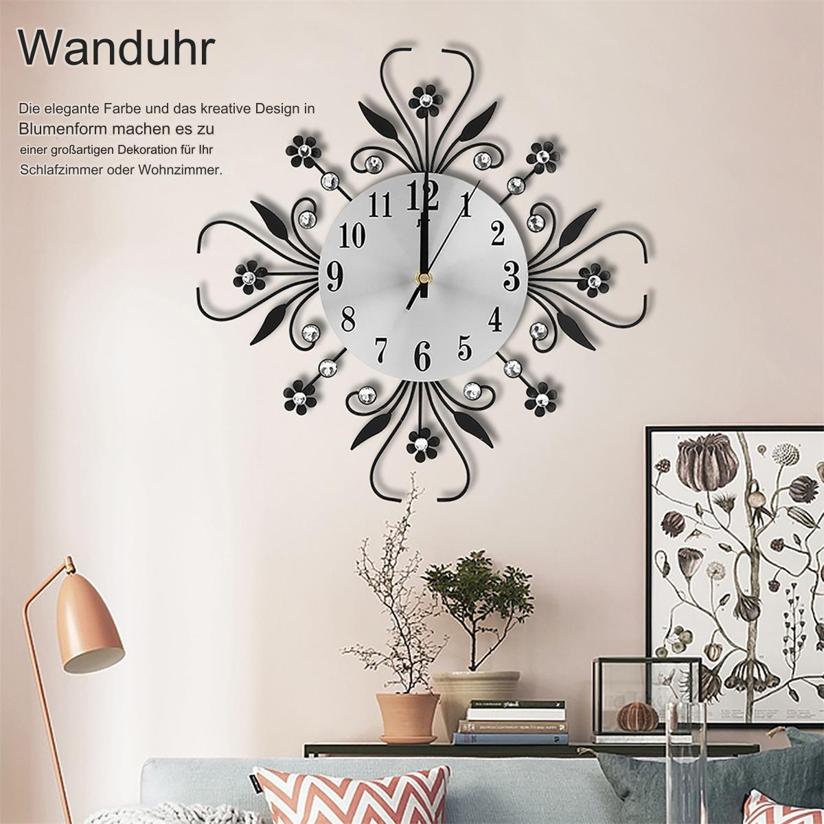 Eine dekorative Wanduhr mit schwarzen floralen Details, die über einem Sofa hängt.