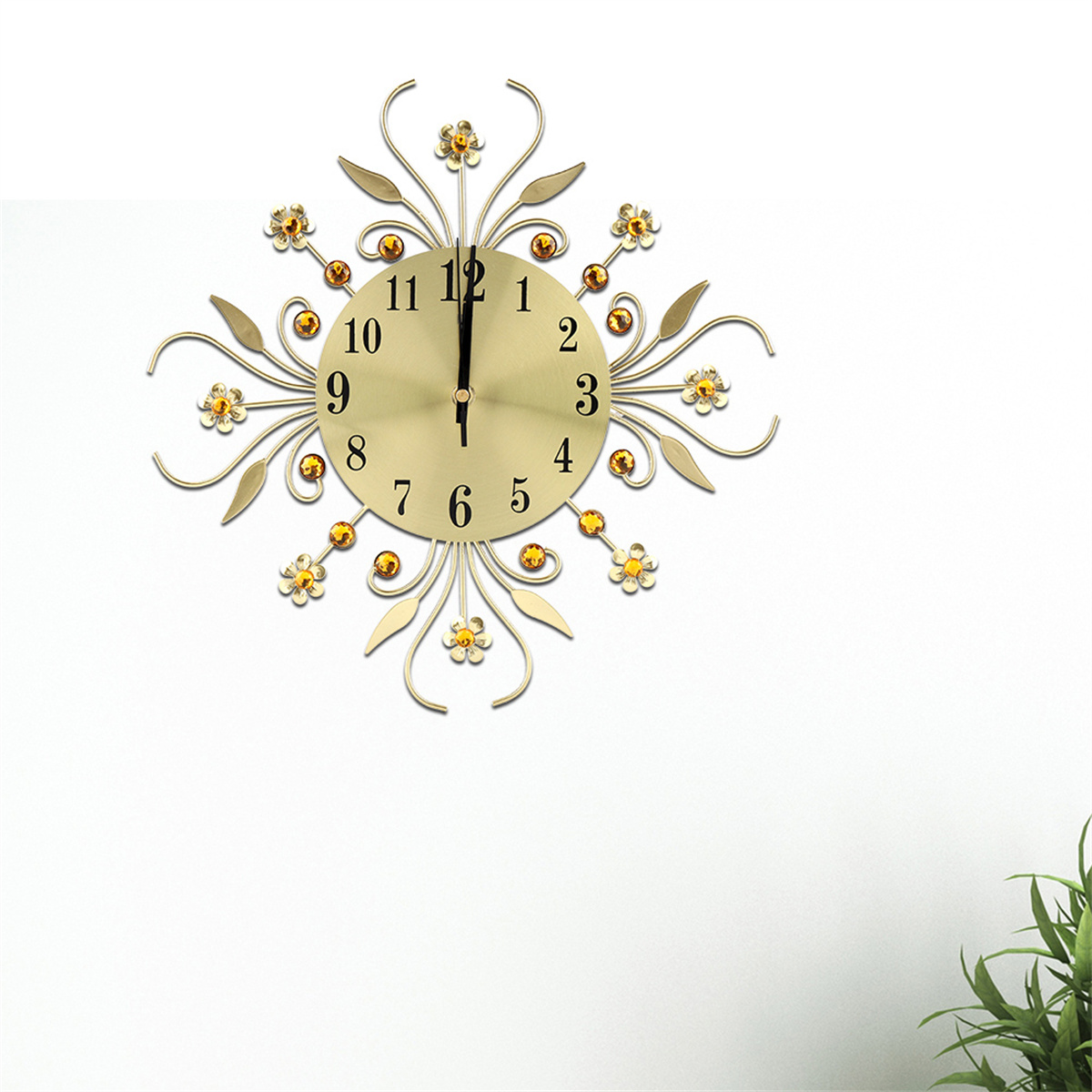 Goldene Uhr mit floralem Design und gelben Juwelen. Die Uhrzeit ist ungefähr 12 Uhr.
