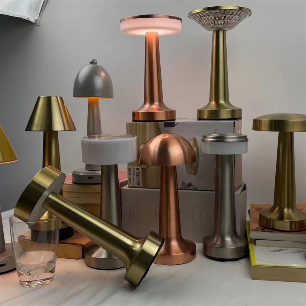 Eine Sammlung von Tischlampen in verschiedenen metallischen Ausführungen auf einer weißen Oberfläche.