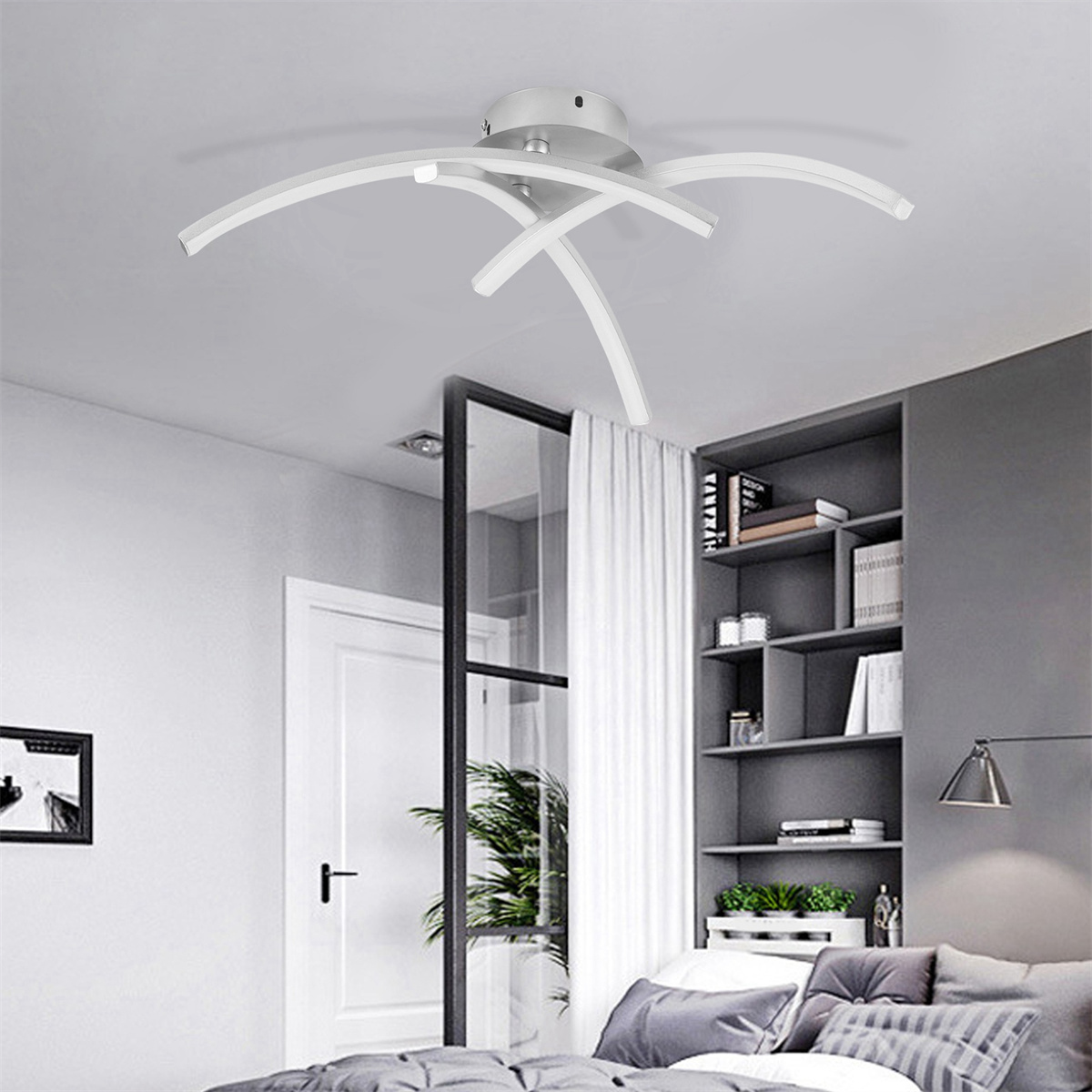Eine silberne, moderne Deckenlampe mit gebogenen Armen, in einem Raum mit Bett und Regalen.
