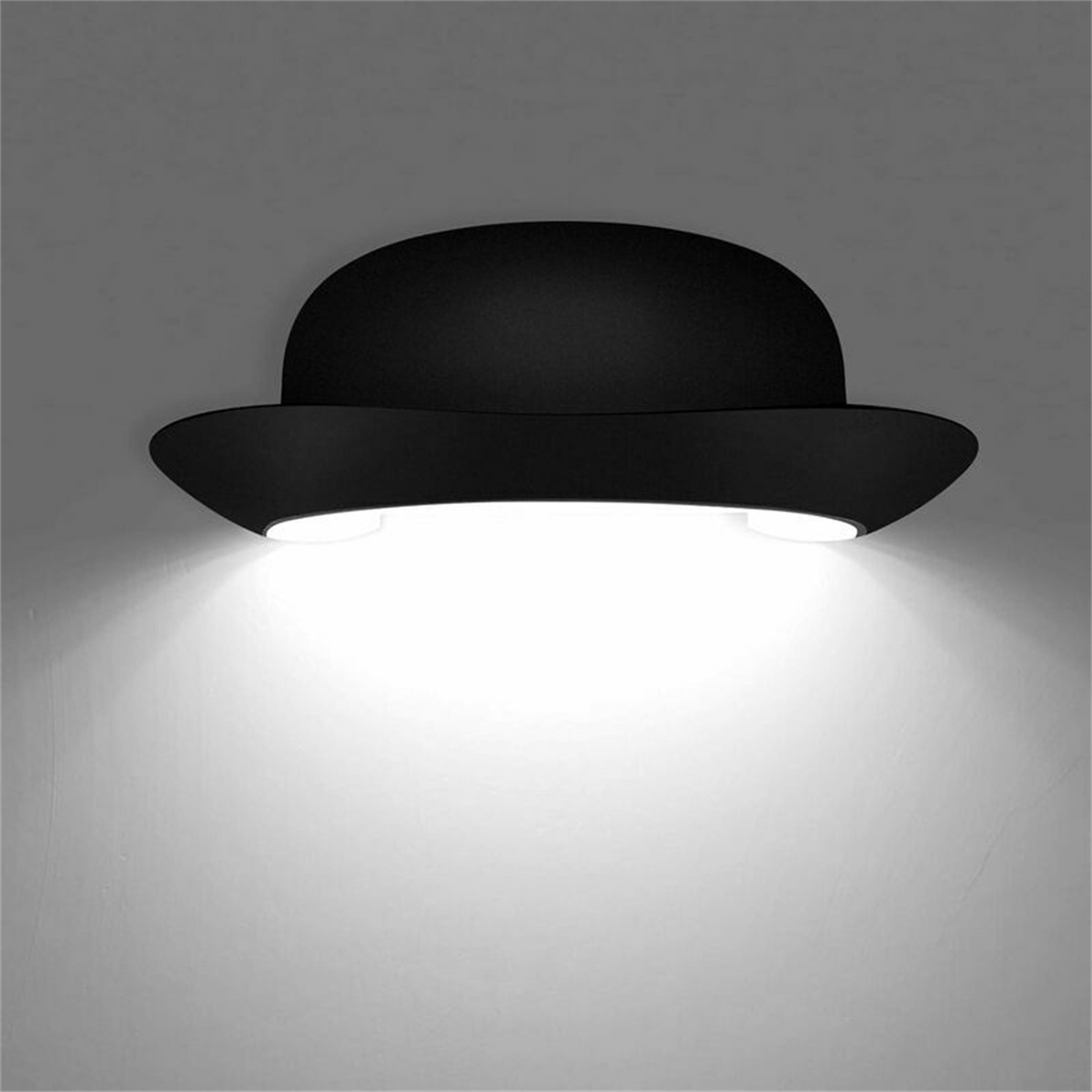 Eine schwarze Leuchte in Form eines Bowlerhutes, die Licht nach unten scheint.