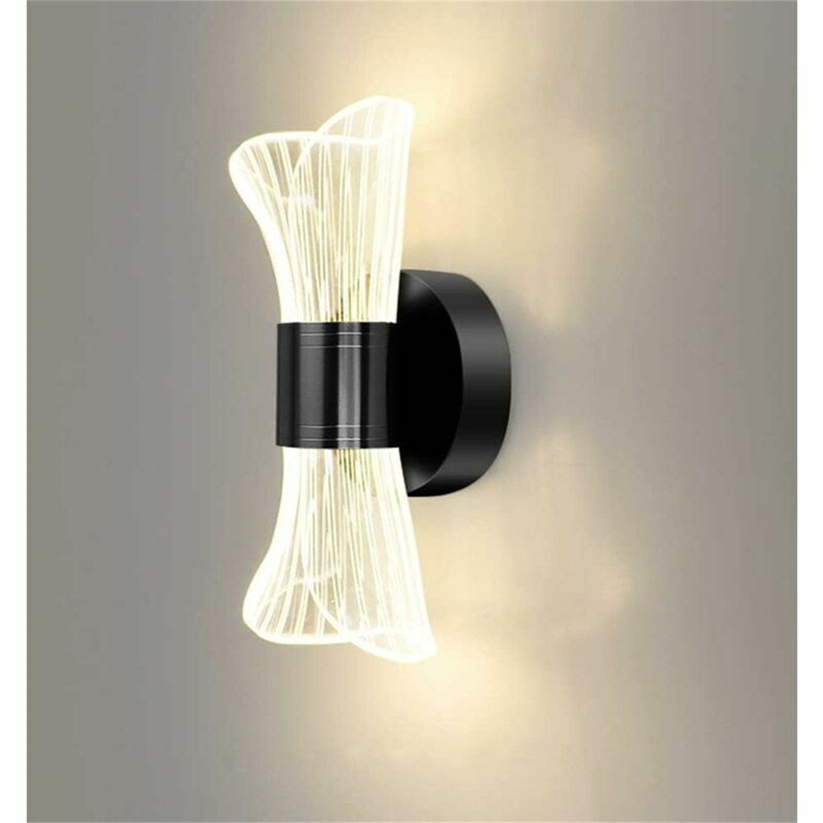 Moderne Wandleuchte, schwarzer Sockel, klare Lichtströme aus einer Sanduhr-förmigen Mitte.