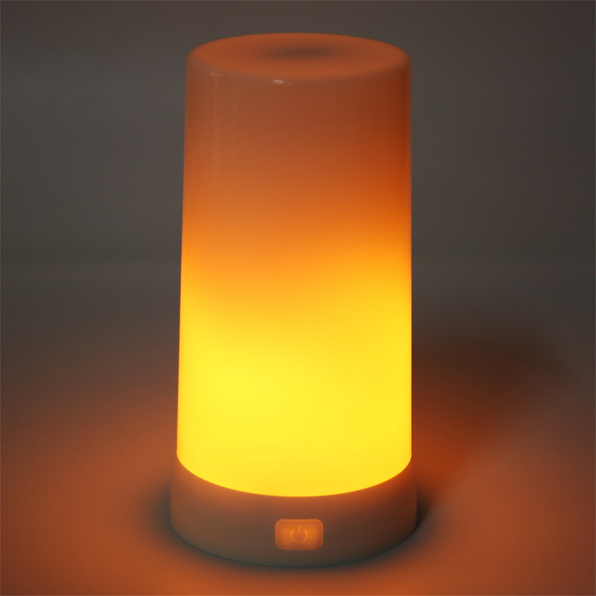 Weißer zylindrischer Lampen, die orangefarbenes und gelbes Licht aussenden. Die Lampe steht.