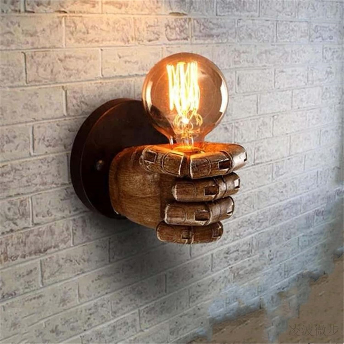 Wandlampe in Form einer Hand, die eine Edison-Glühbirne hält.
