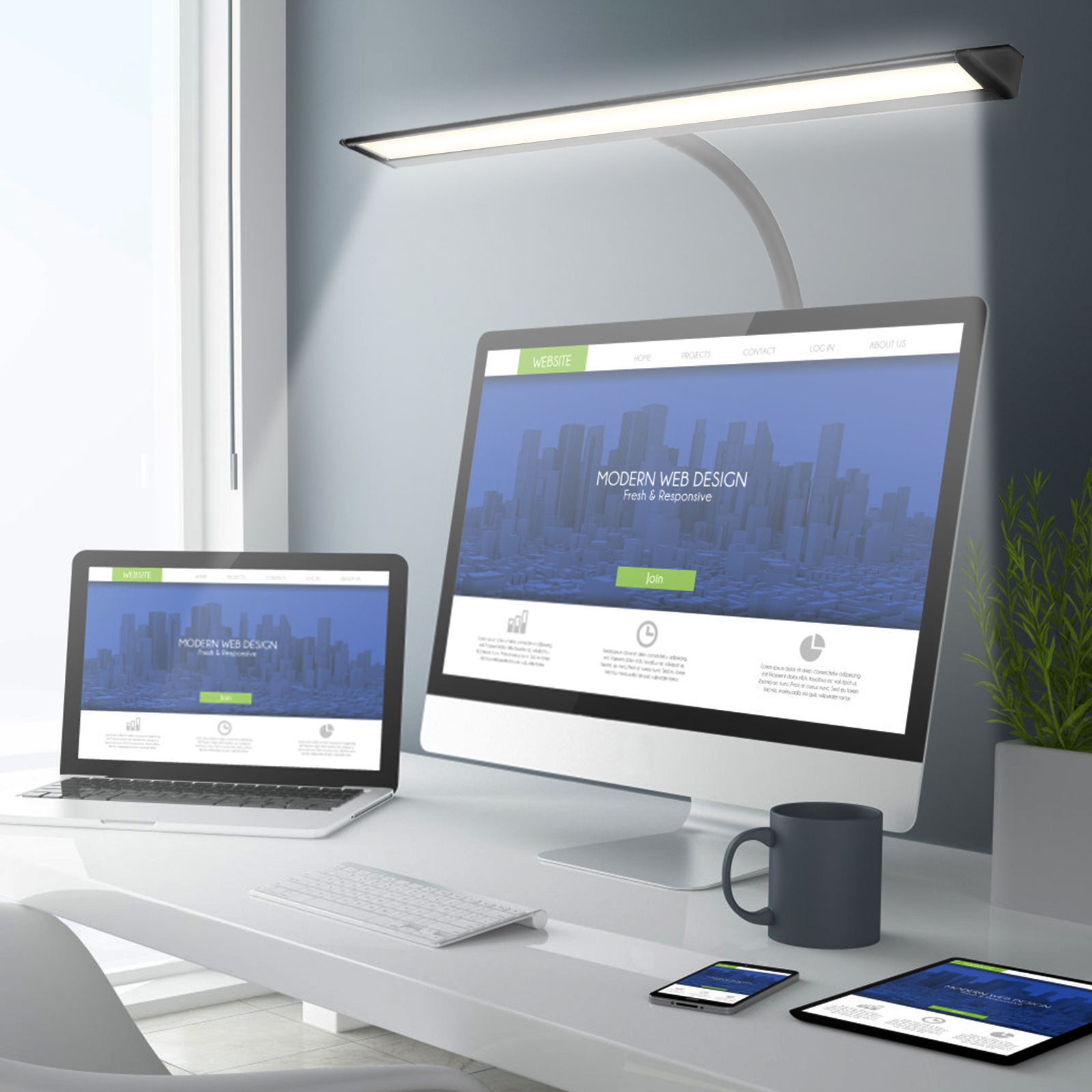 Bureau met laptop, monitor met website, tablet, telefoon, mok en bureaulamp in moderne kantooromgeving.
