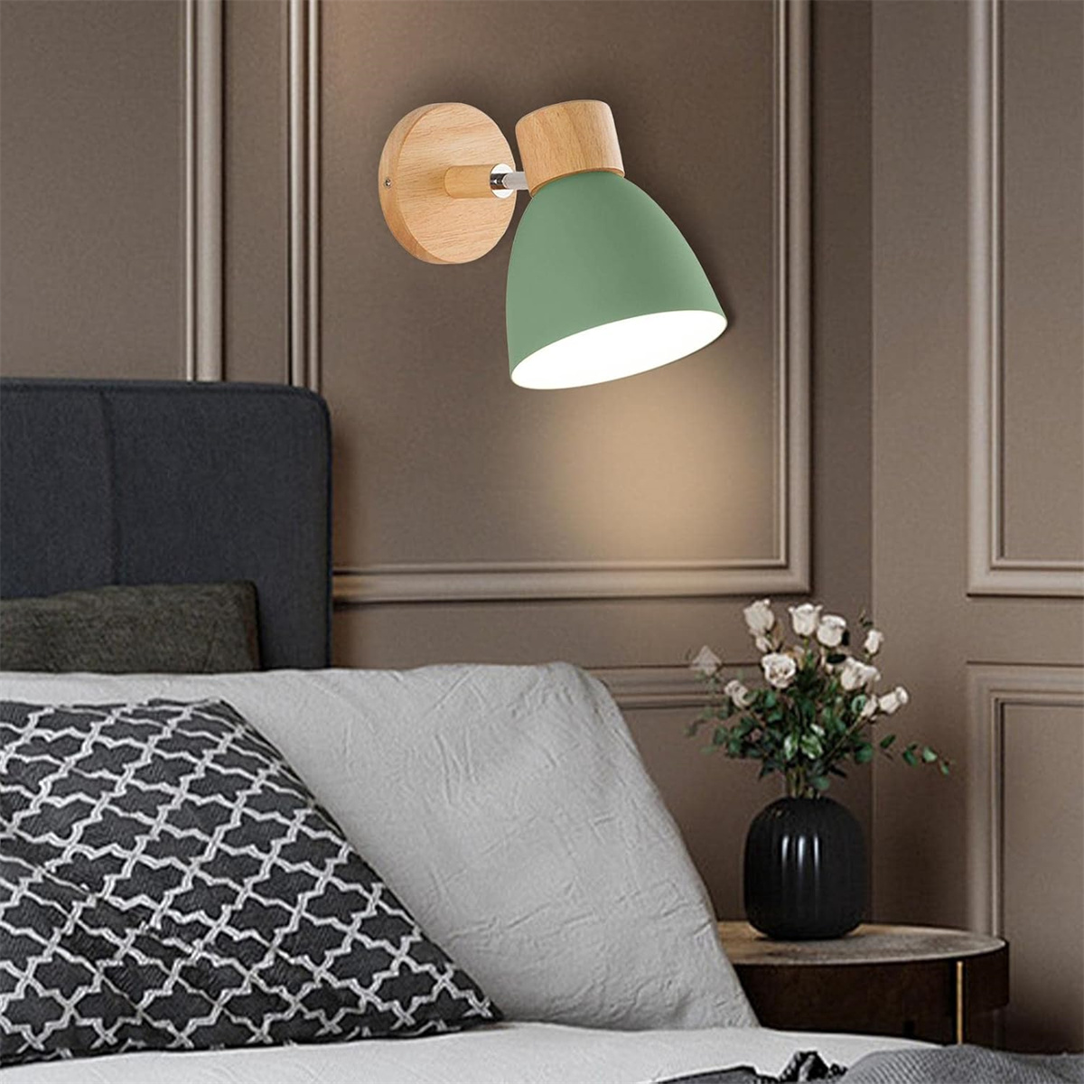 Grüne Wandlampe mit Holzsockel, wirft Licht an die Wand.