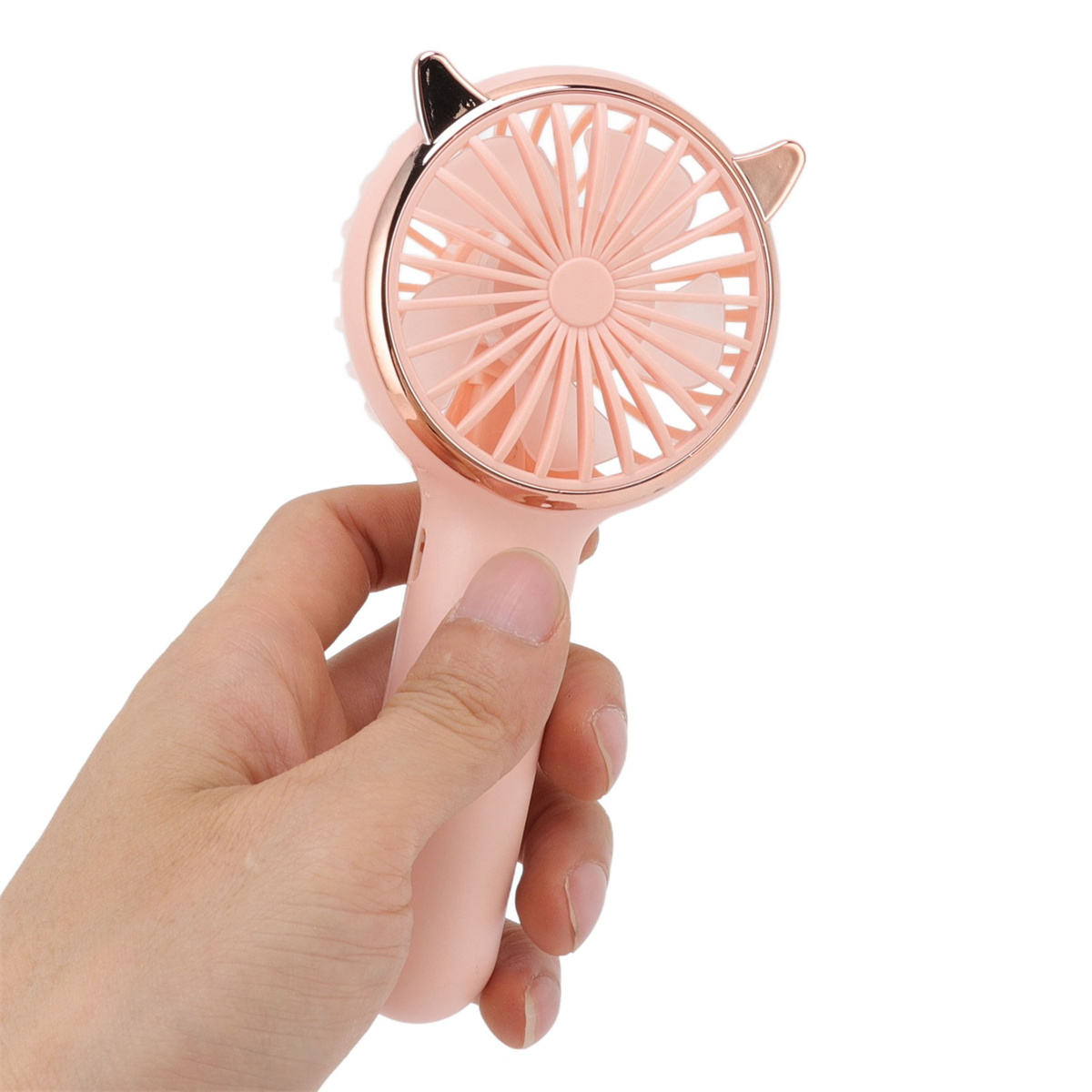 Eine Hand hält einen rosa Handventilator mit Katzenohren, weißer Hintergrund.