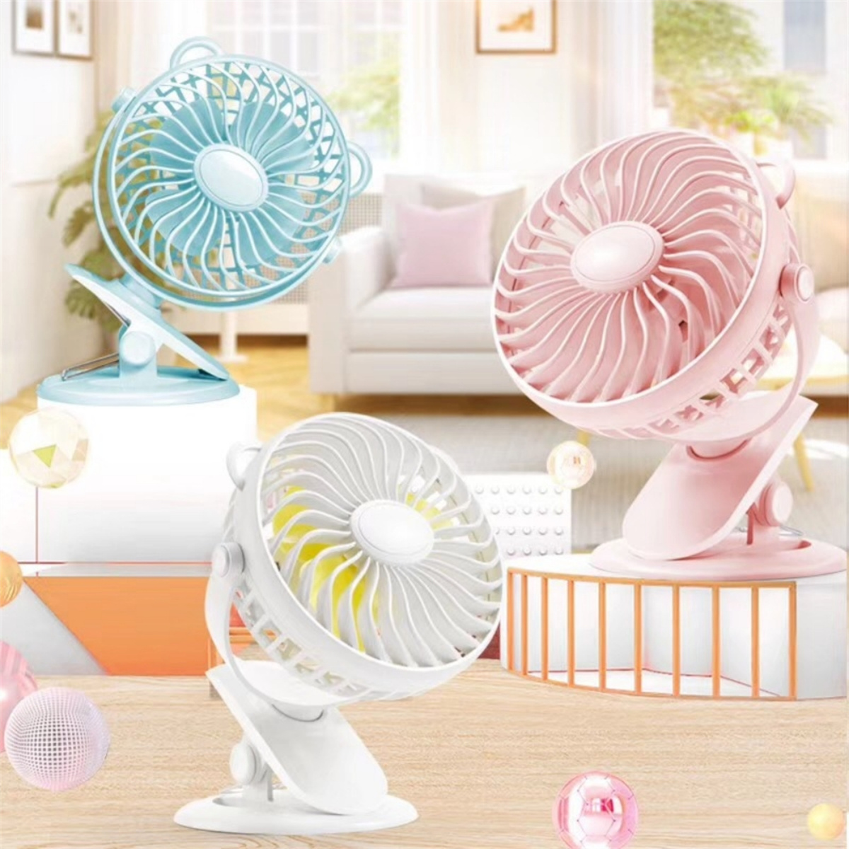 Drei bunte Mini-Ventilatoren im Clip-On-Stil, hellblau, rosa und weiß.