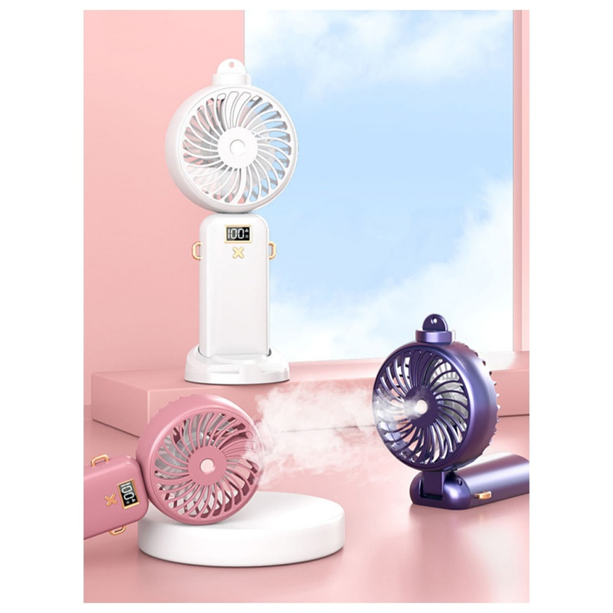Drei tragbare Ventilatoren auf einem Podest. Einer rosa, einer weiß und einer lila, mit blauem Himmel.