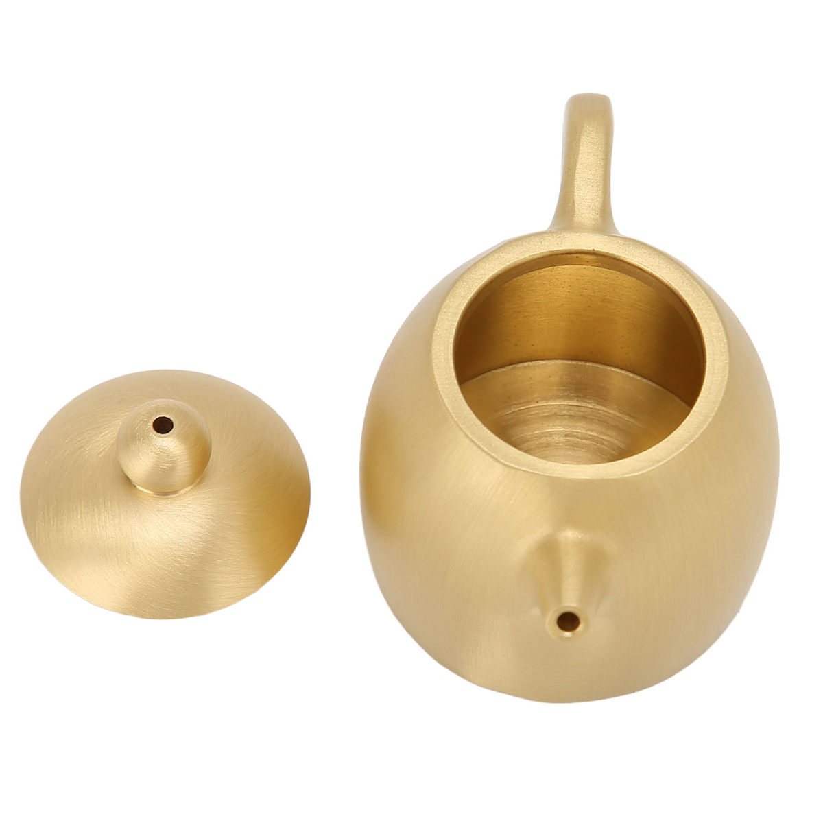 Goldene Teekanne und Deckel auf weißer Oberfläche, Draufsicht.