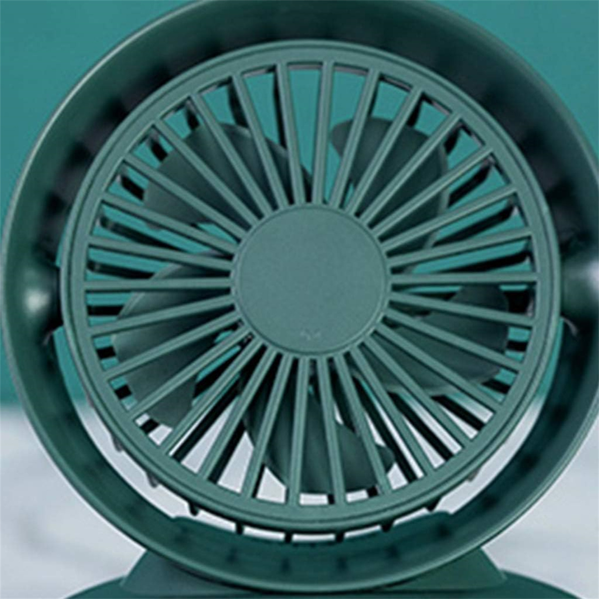 Eine Draufsicht auf einen teal-farbenen Lüfter mit Flügeln und Schutzgitter.