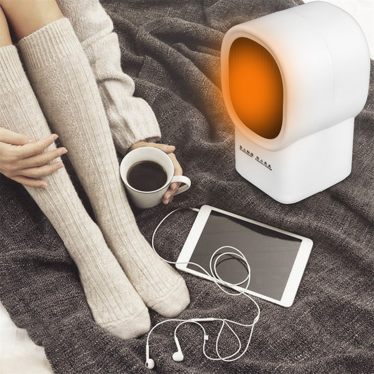 Eine Person sitzt mit kniehohen Socken und einer Heizung. Eine Tasse und ein Tablet sind in der Nähe.