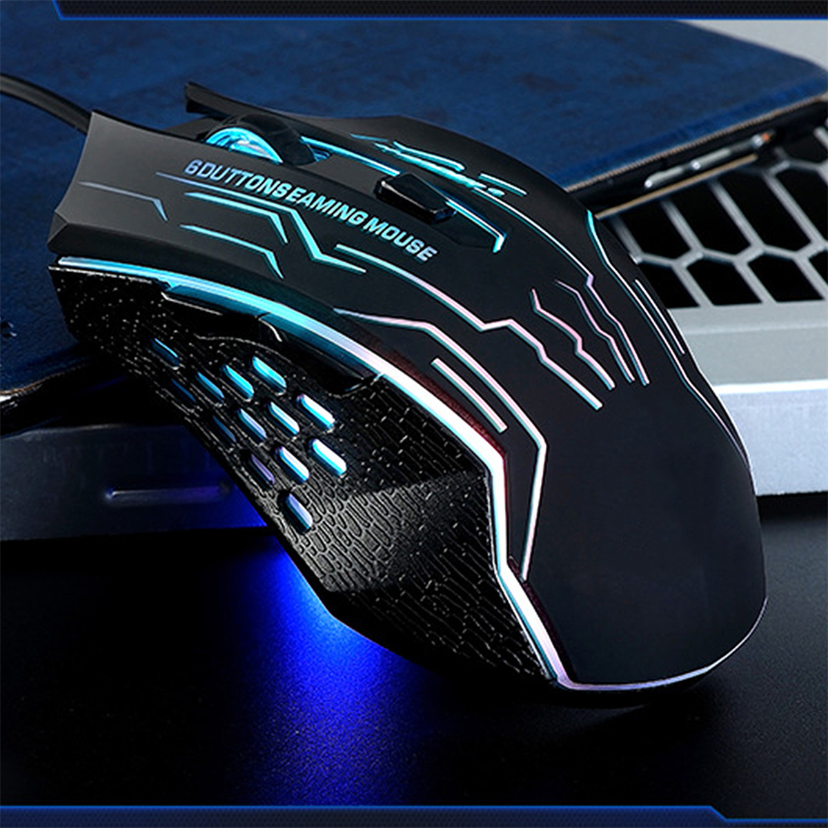 Eine schwarze Gaming-Maus mit blauen und weißen Lichtern. Sie liegt auf einer dunklen Oberfläche.