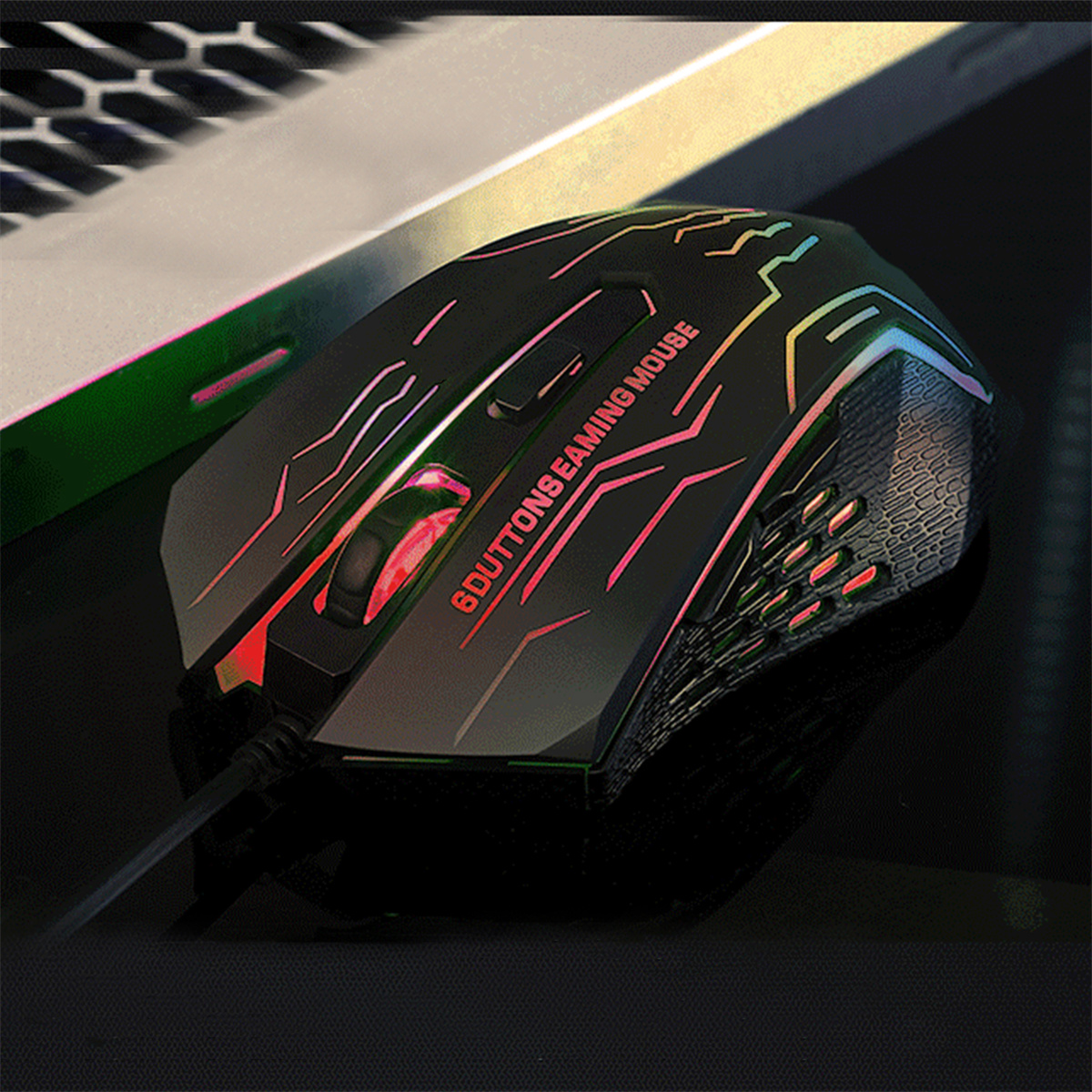 Gaming-Maus. Schwarz mit farbigen Lichtern, kabelgebunden, auf dunkler Oberfläche.