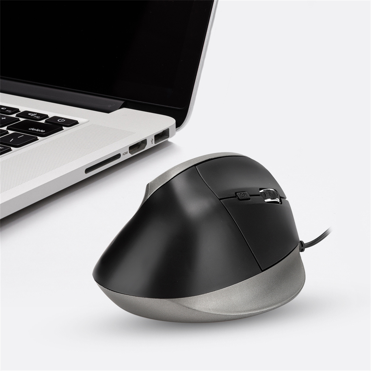Ergonomische schwarz-graue Maus neben einem Laptop, abgewinkeltes Design.