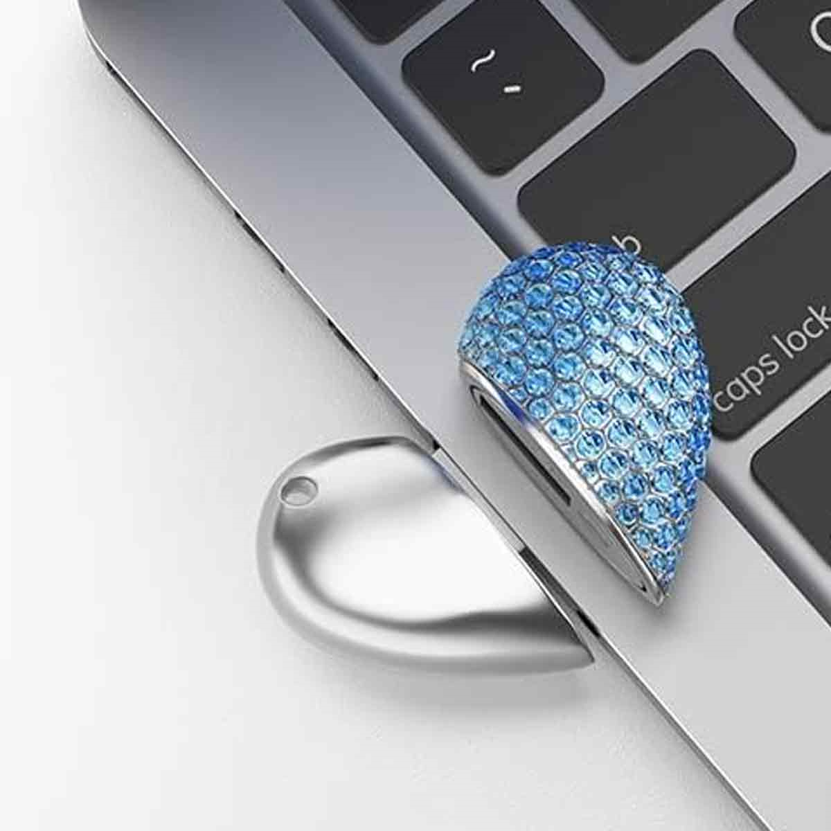 Eine blau geschmückte Tastenkappe auf einer Laptop-Tastatur, mit silbernem Metall darum herum.