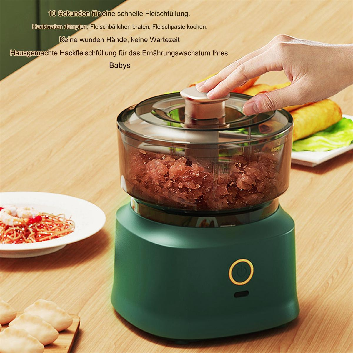 Ein grüner Foodprozessor mit Essen darin. Eine Hand schwebt über dem Deckel.