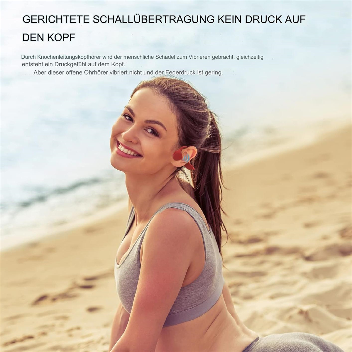 Eine Frau mit Kopfhörern lächelt am Strand.