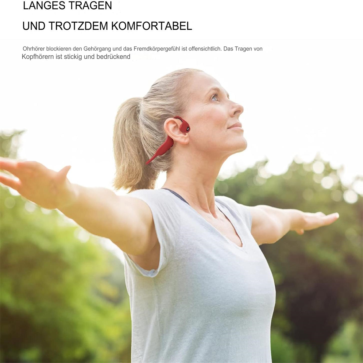 Eine Frau mit roten Ohrhörern, die Arme ausgestreckt, nach oben blickend, mit hellem Hintergrund.