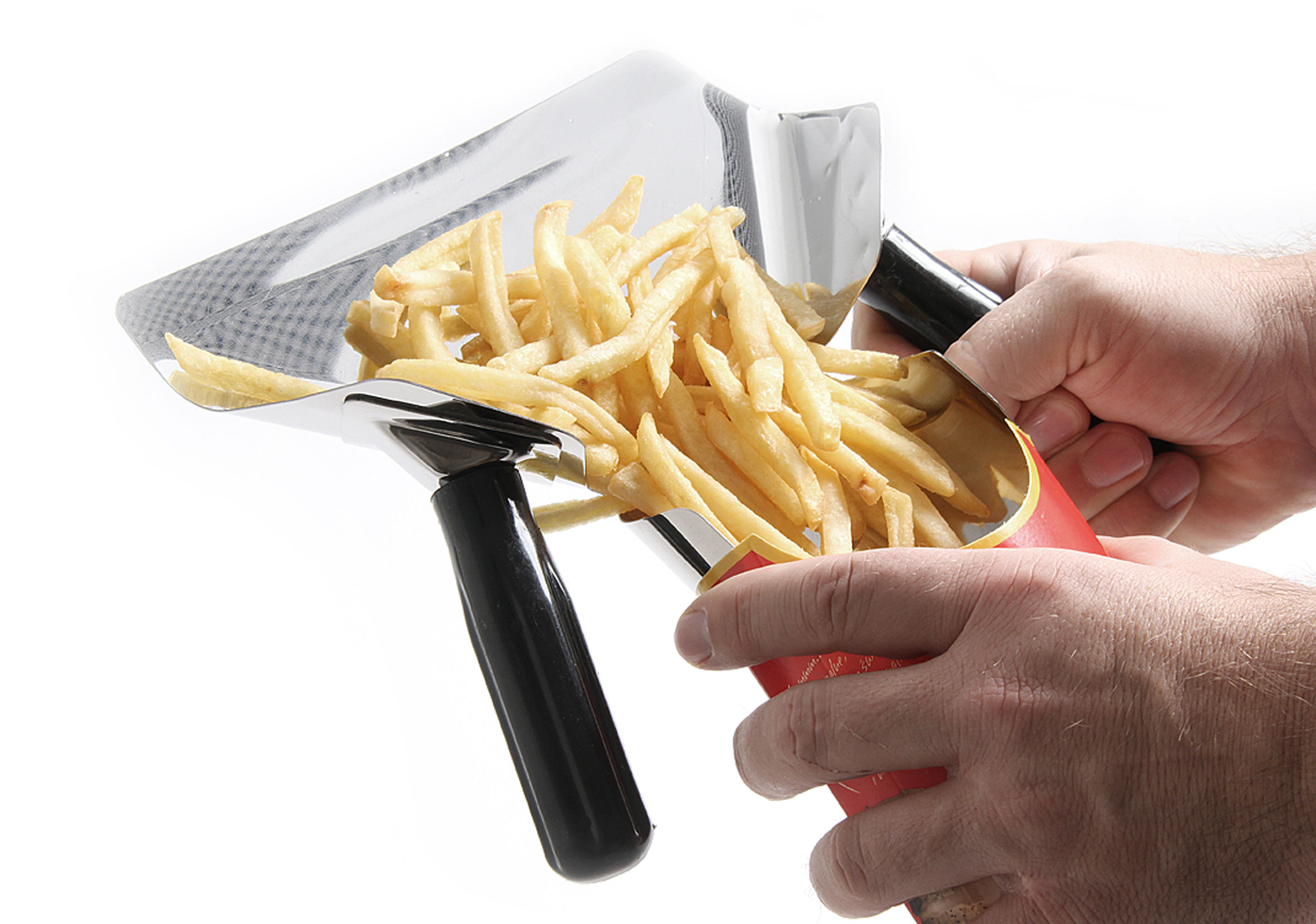 Persona che tiene una paletta piena di patatine fritte, versandole in un contenitore rosso e bianco. Sfondo bianco.