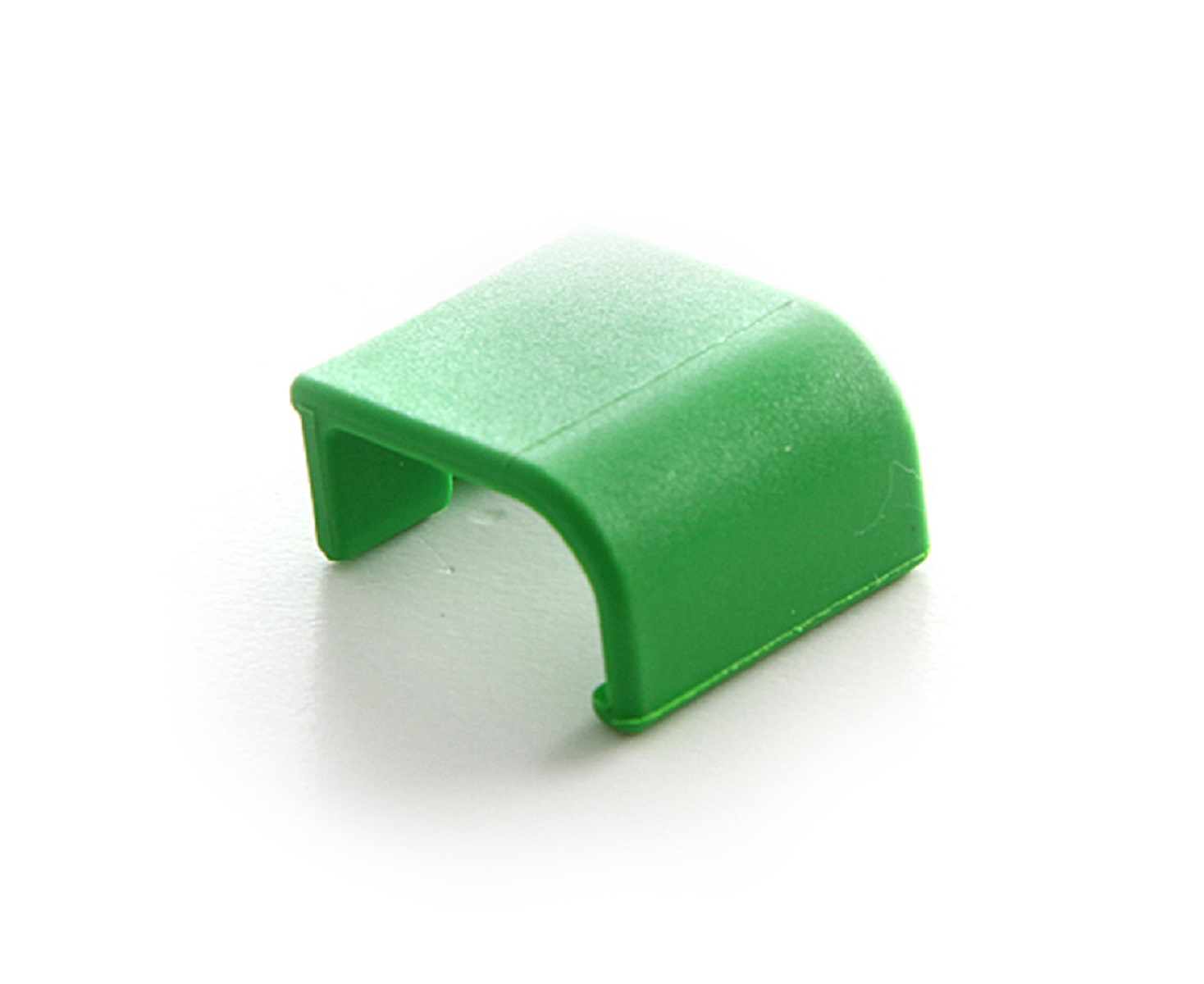 Piccola clip di plastica verde, forma curva, sfondo bianco.