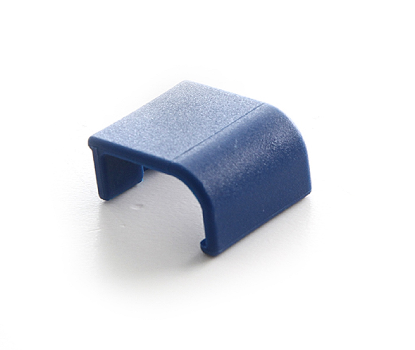 Un piccolo pezzo angolare di plastica blu su una superficie bianca.