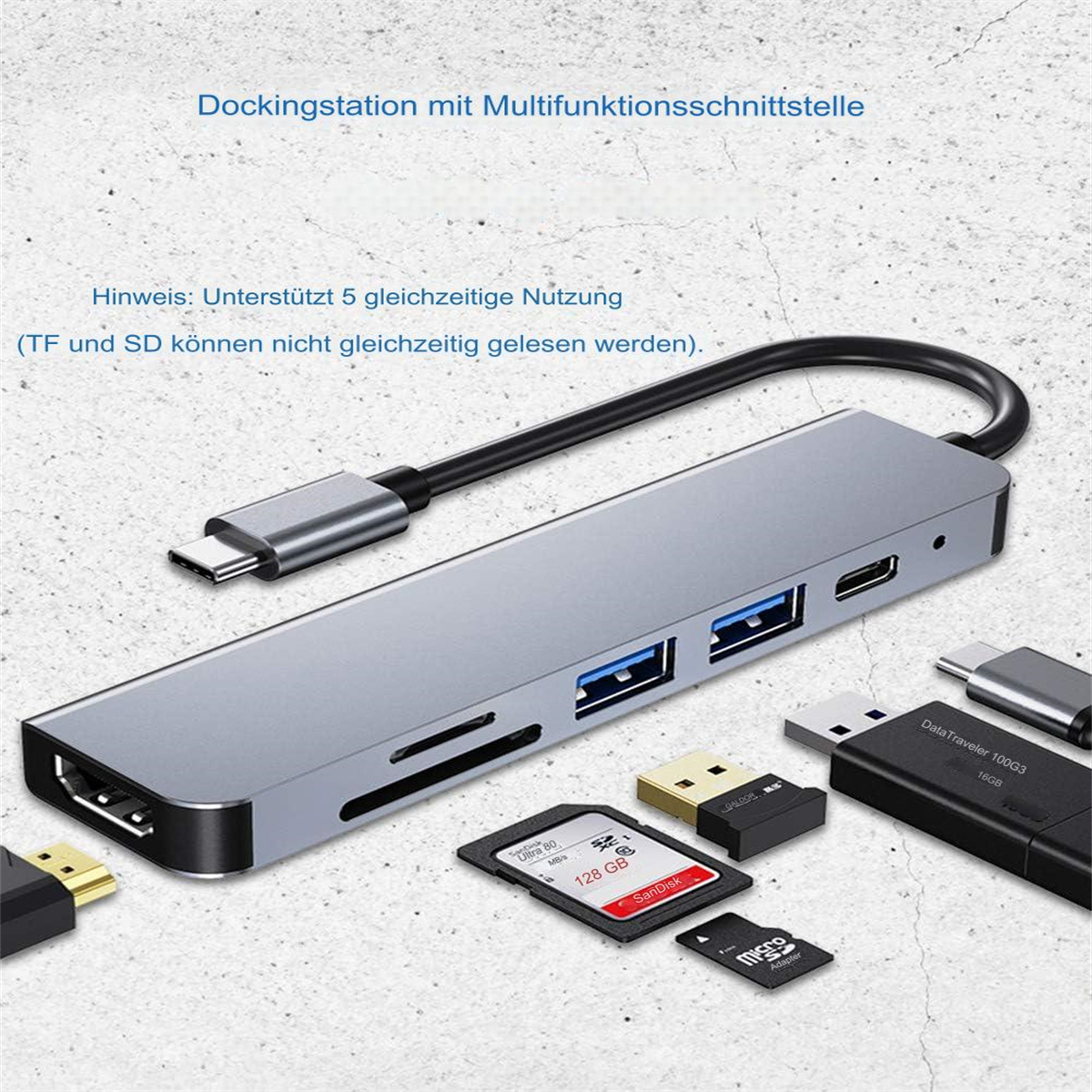 Silberner Hub mit Anschlüssen, SD-Karten und USB-Laufwerken auf grauem Untergrund.